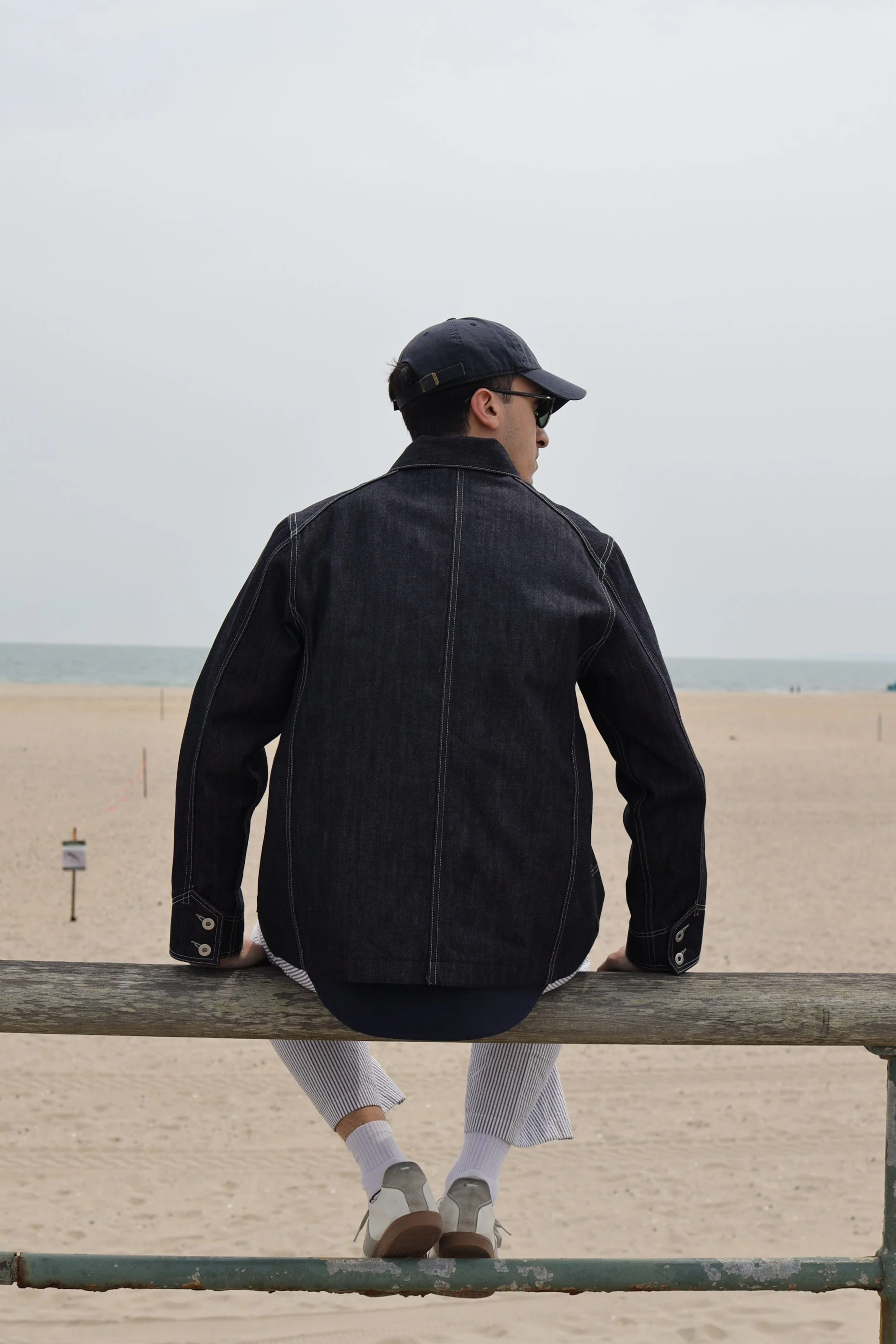Back view of selvedge denim coverall jacket worn on body outdoors