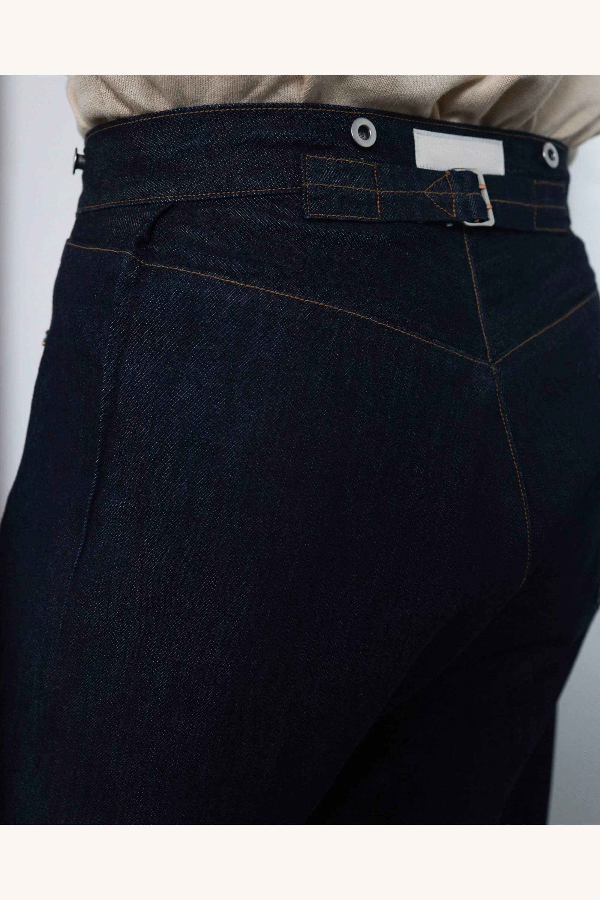 Detail of original selvedge denim jeans waistband with metal buttons