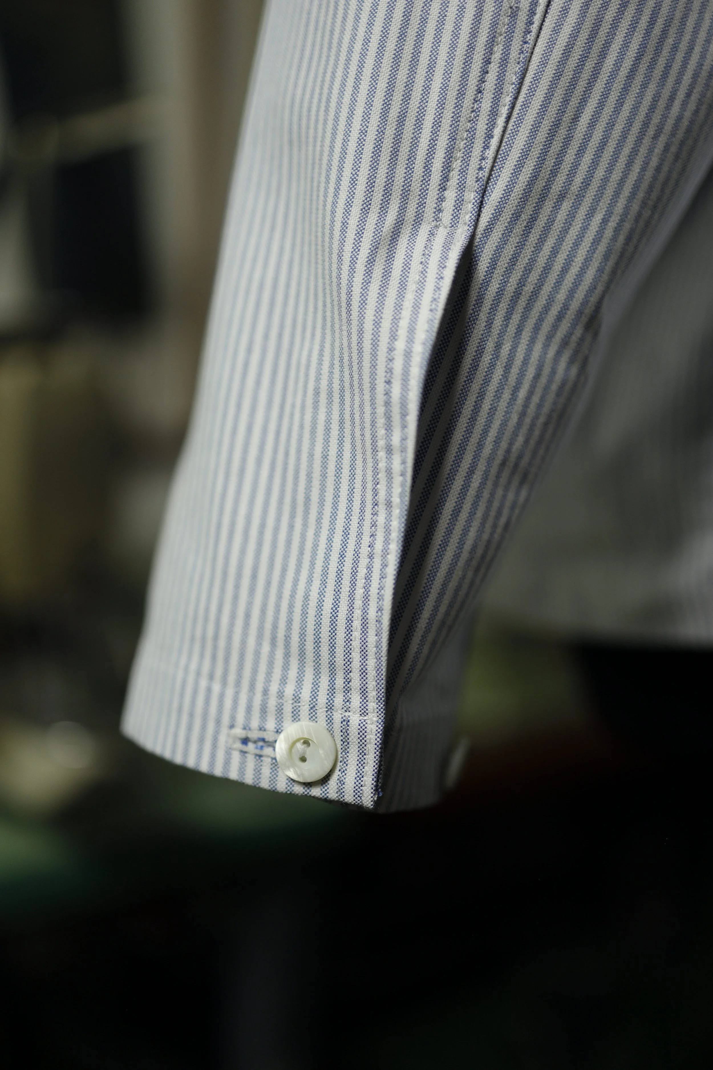 Detailed view of the Ocean Blue Cotton Oxford Pullover Shirt cuff with mother-of-pearl style button and tailored blue striped Oxford fabric.