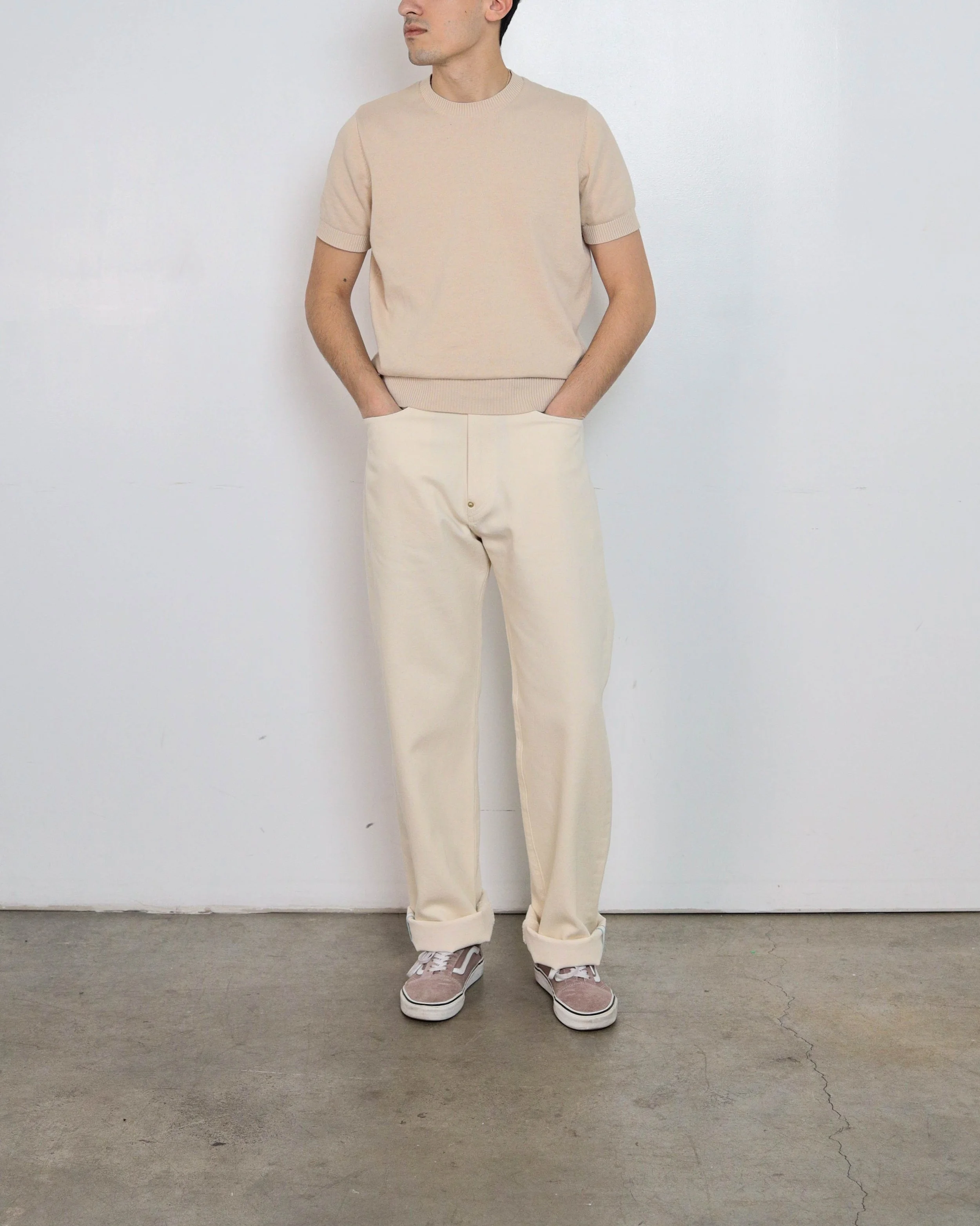 On‑body front view of ecru selvedge denim jeans by [ko’lōn] with a straight‑leg fit, classic five‑pocket design, and button fly closure.