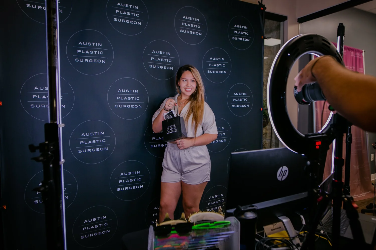 Guest posing in front of a custom logo backdrop at a company event in Austin, Texas