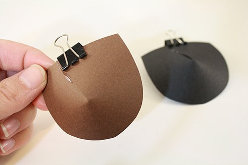 A pair of card-stock eyepatches.
