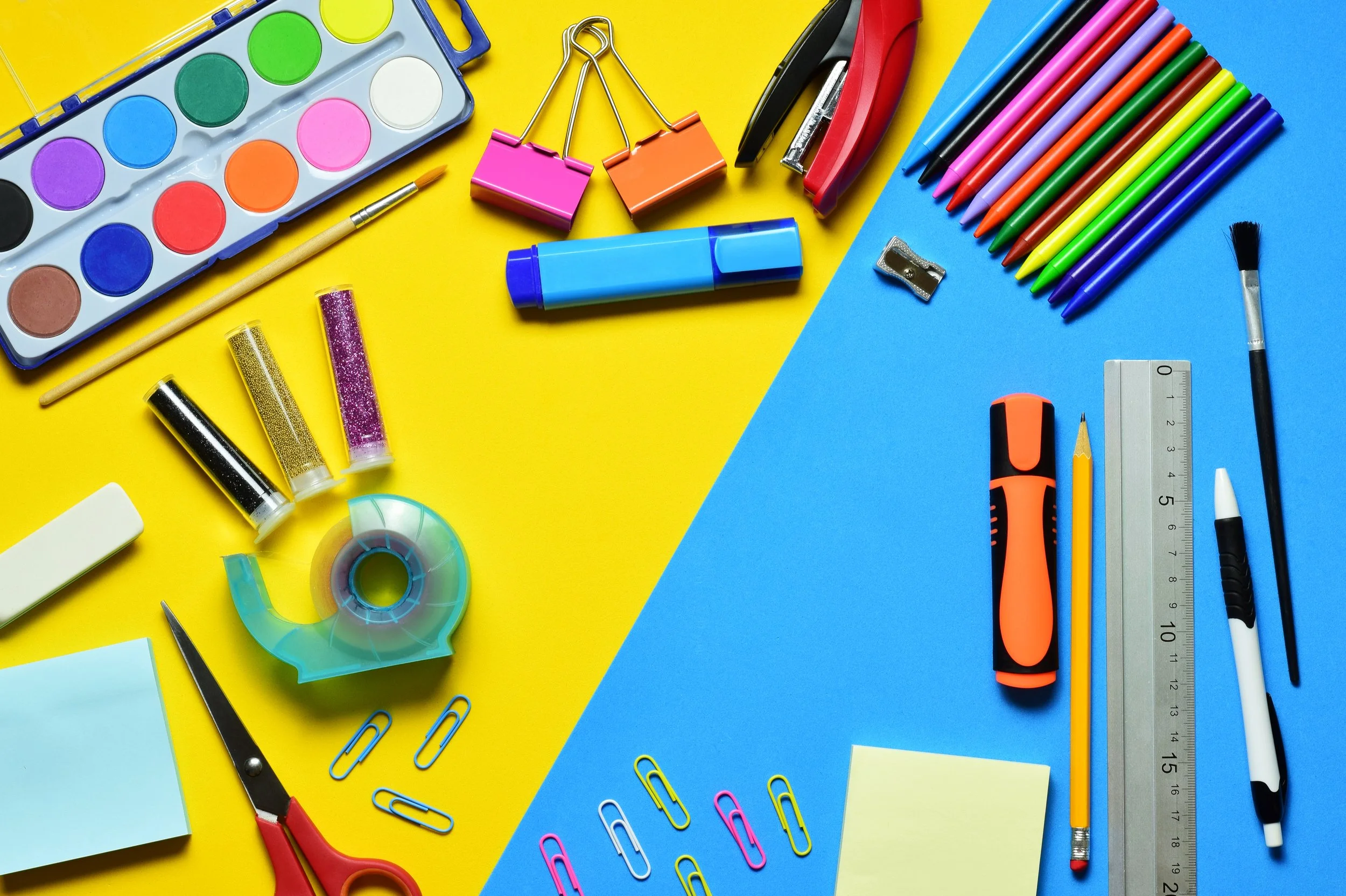 Various school supplies on a yellow and blue background.