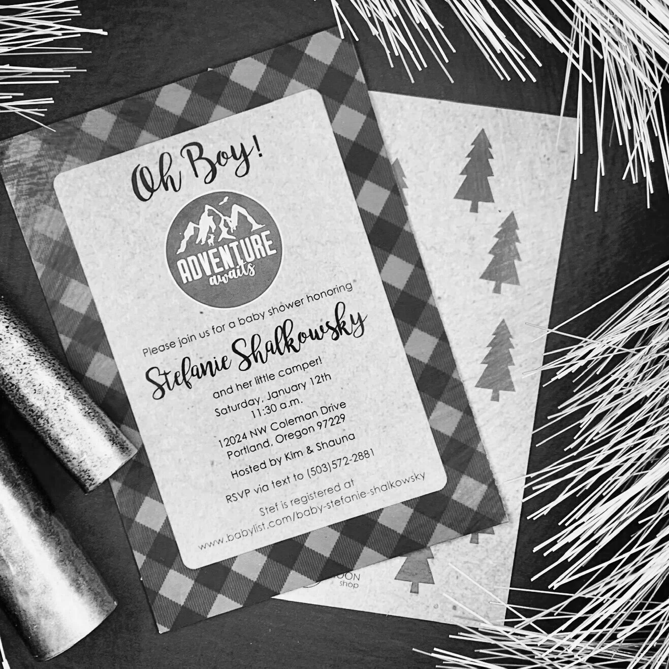 
This fun camping-themed baby shower called for a unique invitation that captured the couple’s love of the outdoors. We designed an invite with a buffalo check border, forest, and a special logo the father created for his newborn. It also helped guid