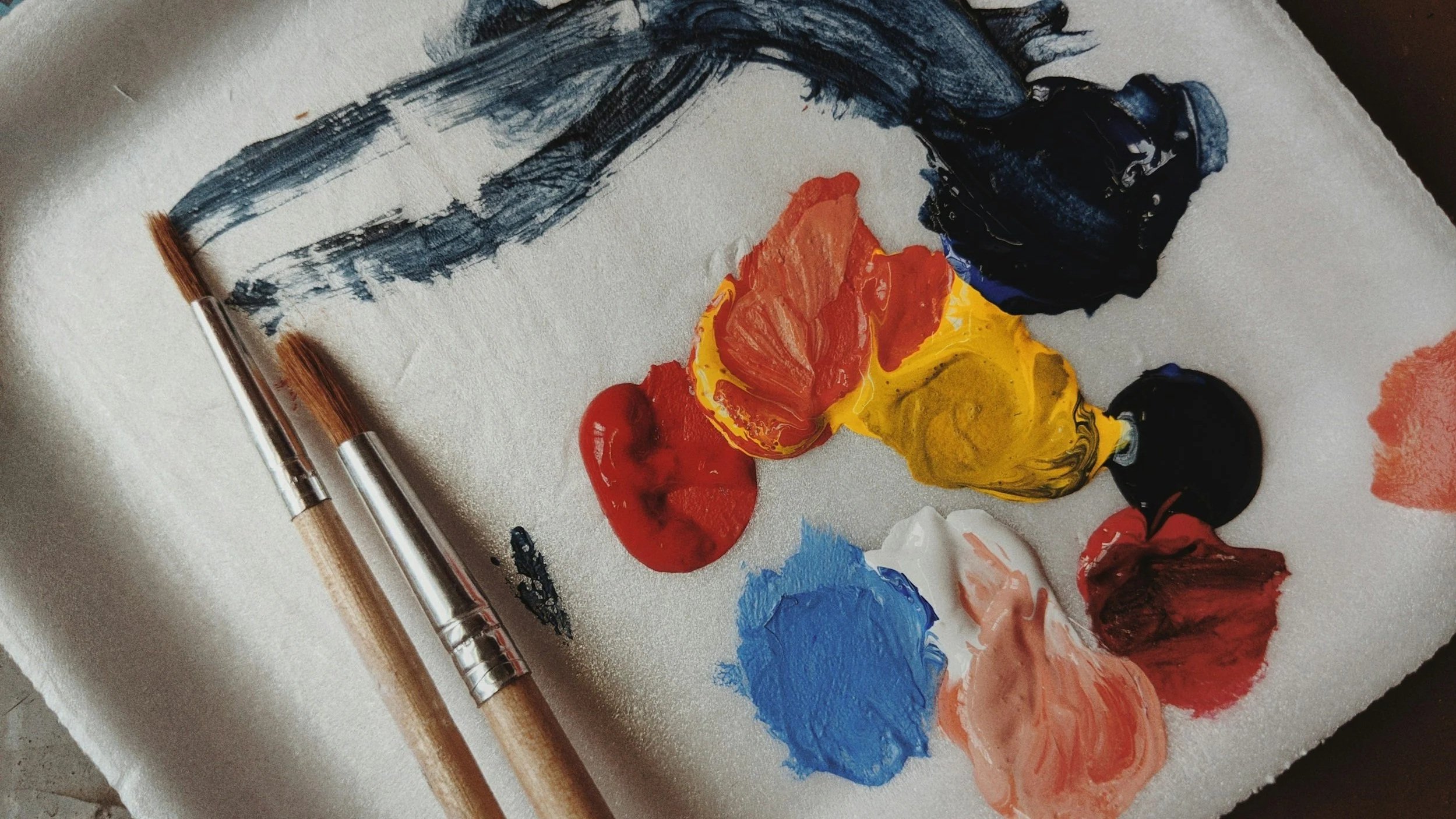 Paint on paint pallet with two brushes on top of it