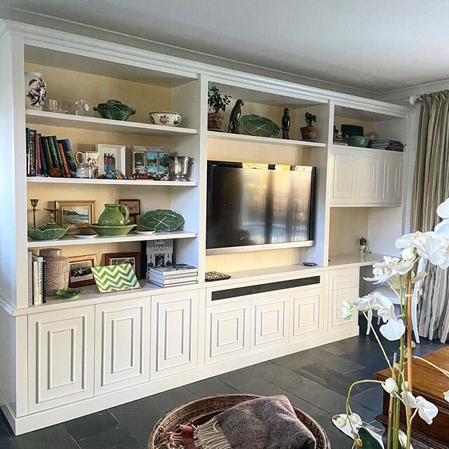 Custom cabinetry.

It&rsquo;s the detail that makes anything custom worthwhile. 
Here I have used a natural grass cloth basket weave wallpaper on the back of this book case to add depth, warmth and interest.  All the doors have custom moulding which 