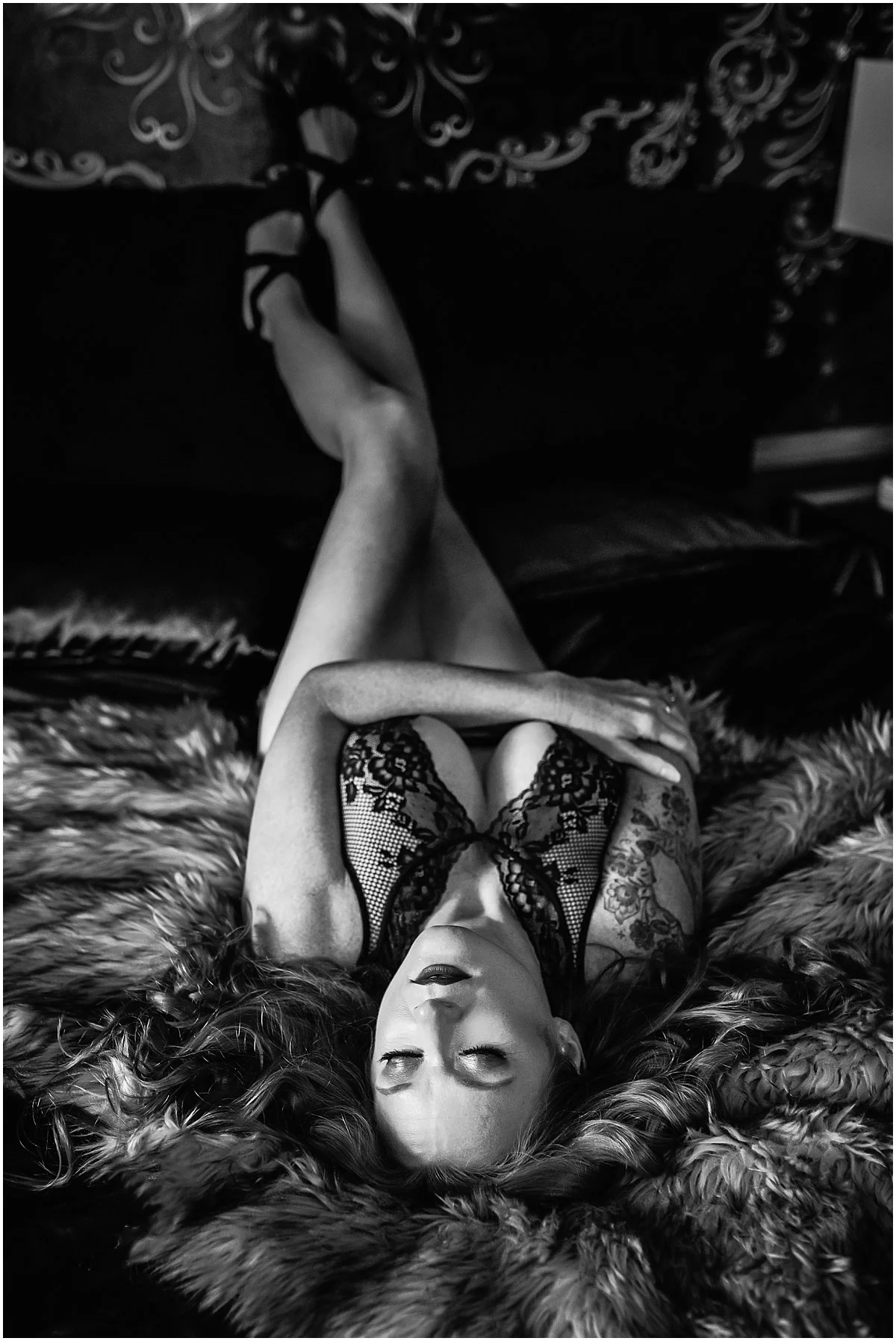 Moody black and white boudoir photography capturing a redheaded woman in an intimate studio setting in Avondale, Florida