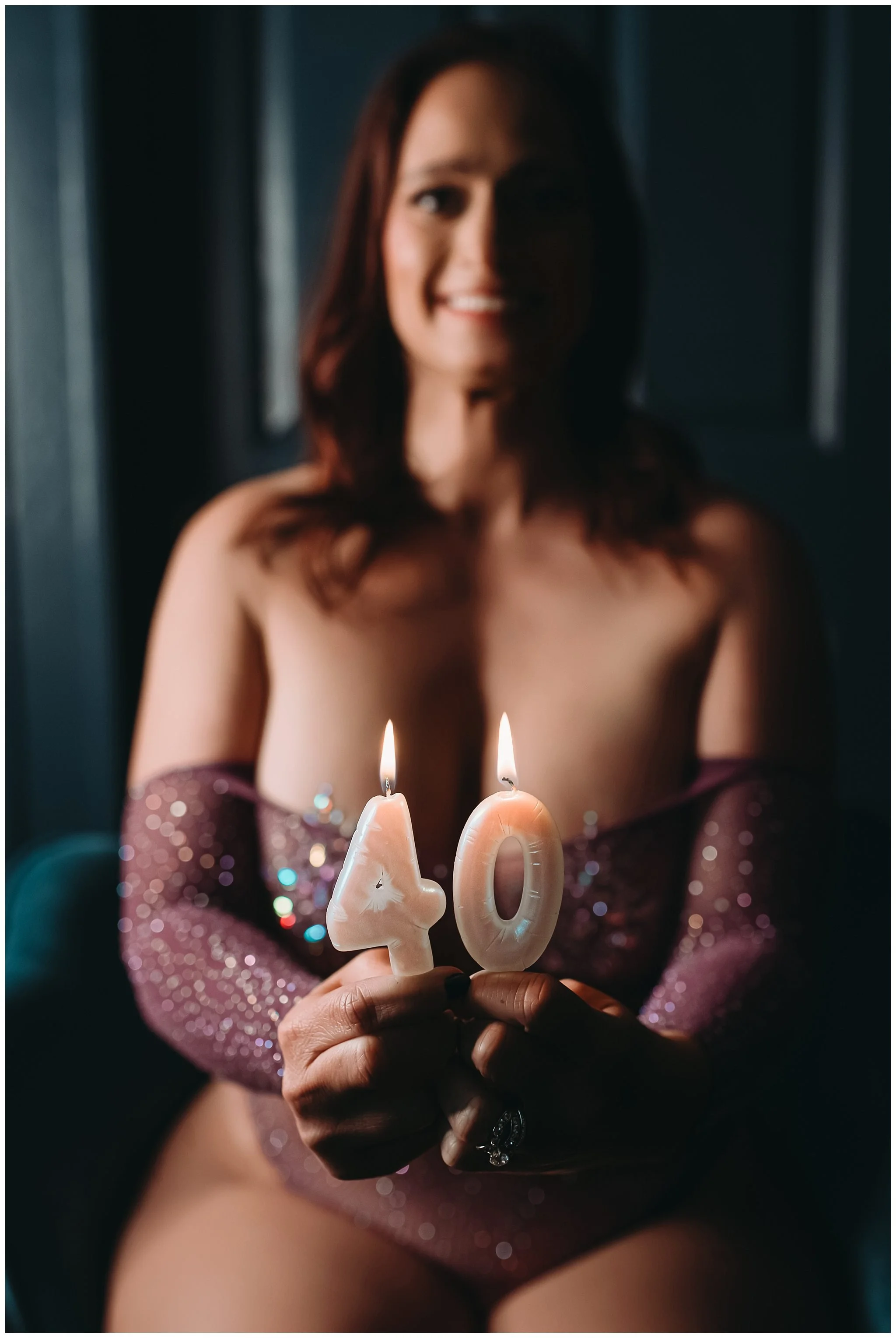 Client holding candles for her 40th birthday during her boudoir photoshoot