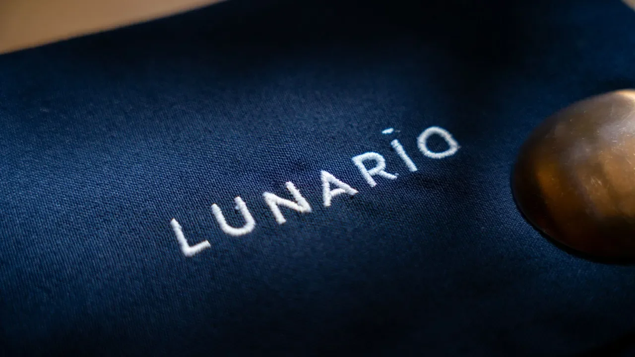 Zoom en la palabra 'Lunario' escrita en letras blancas sobre tela azul oscura.