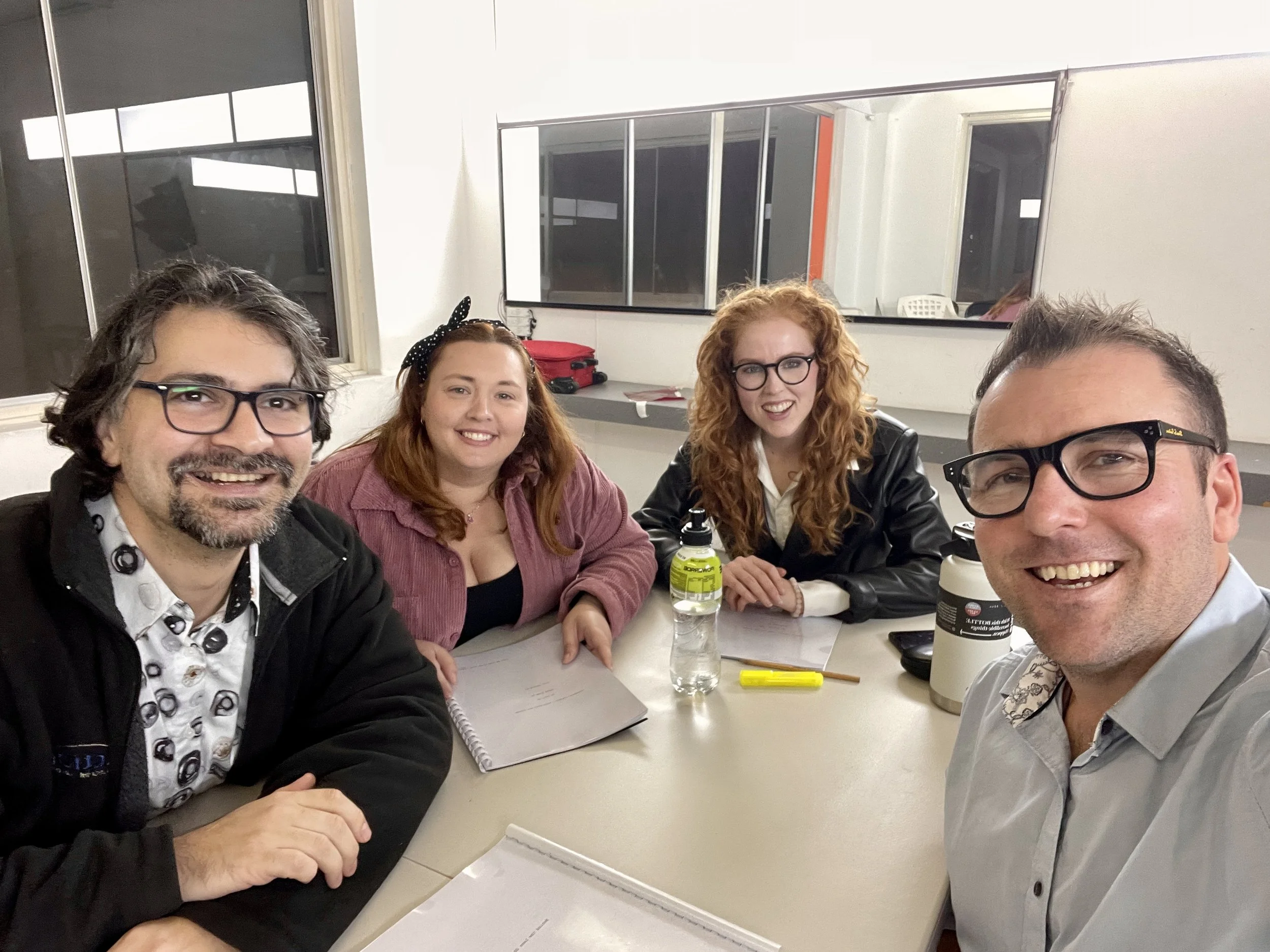 Picture of filmmaker Mark Regan with the three actors at a table read of the Behind the Lens show