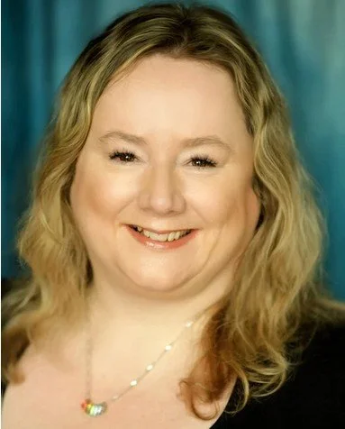 Woman with blonde hair on black back ground looks into distance