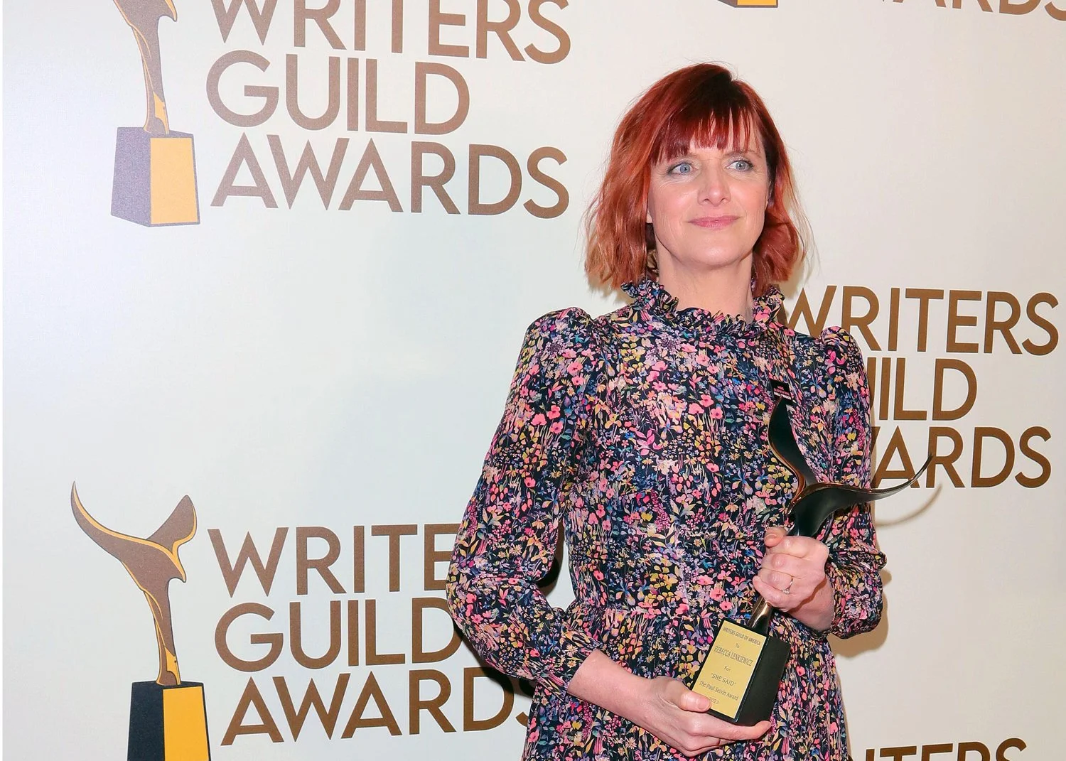 Rebecca Lenkiewicz Director Writer Holds writers Guild Award in flowery dress at awards ceremony