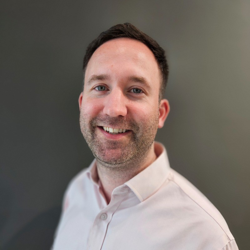 Ryan Horne, risk analyst, aspect capital, middle aged man, smiles at camera, wearing walking coat, infront of mountain.