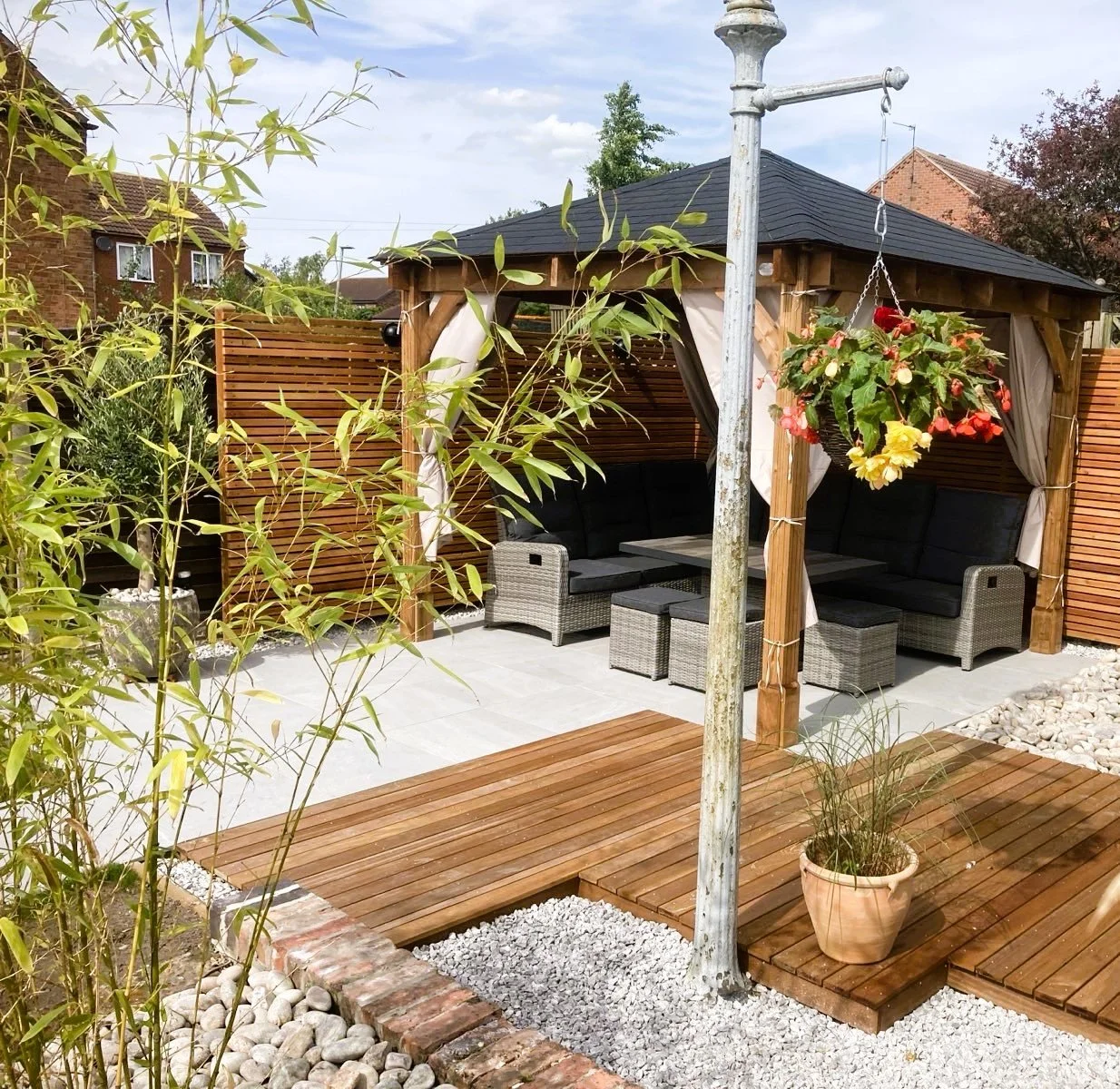 Yellow Balau decking, porcelain paved patio, cobbles, gravel and a new gazebo.  A cozy corner for relaxtion.