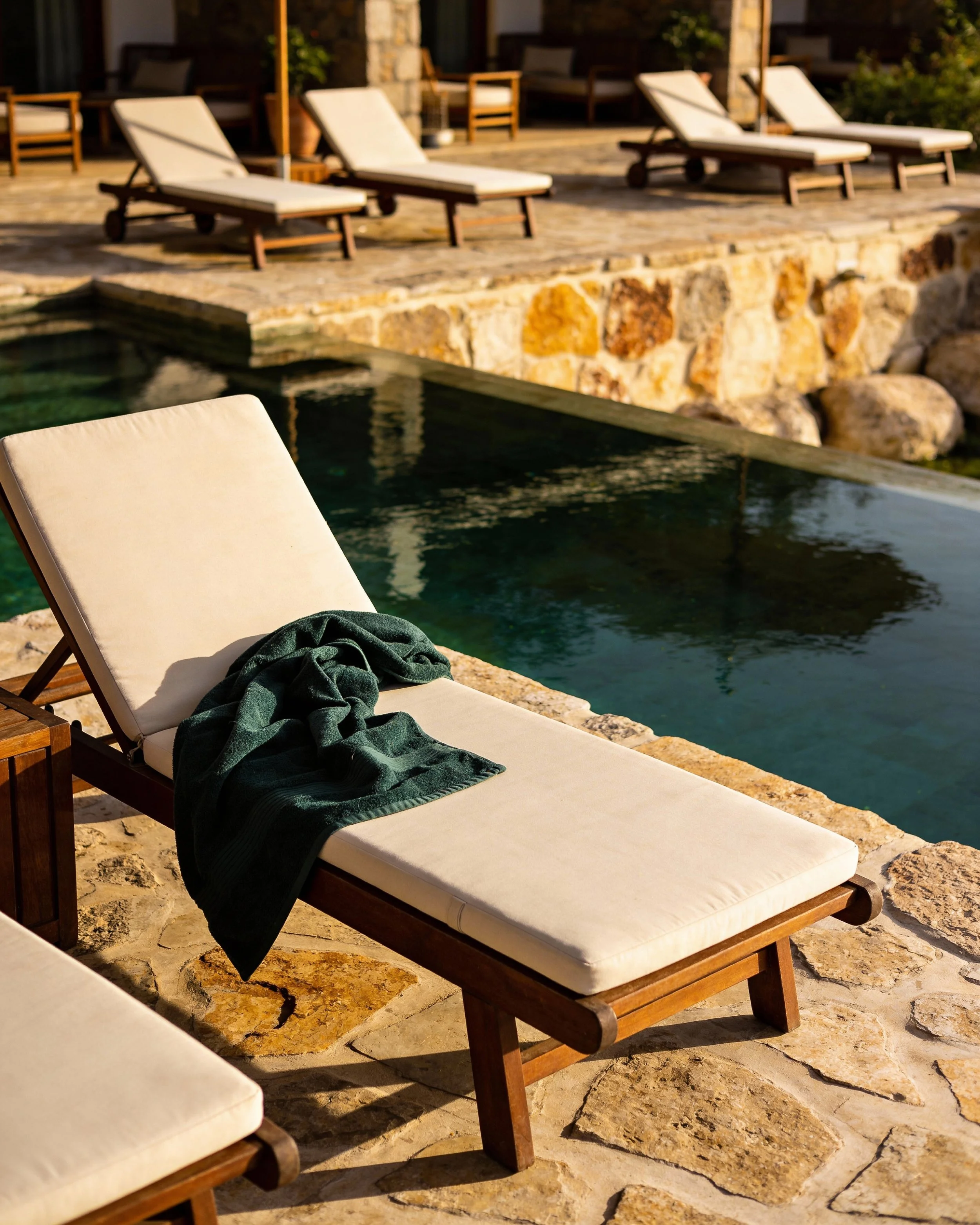 Serviette de l'Hôtel Case Amanyé posé sur un transat au bord de la piscine 