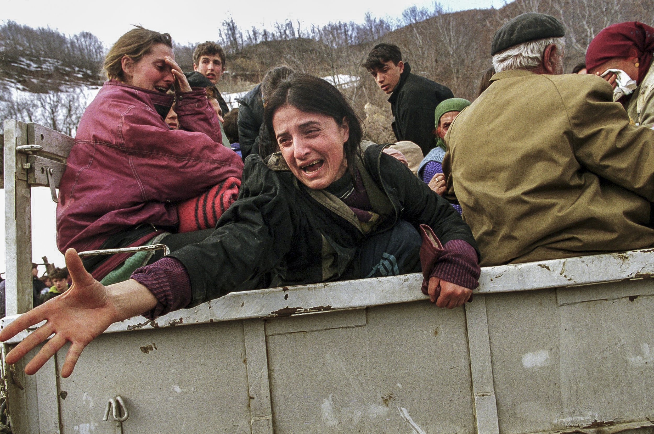 A woman cries as she is split from her family as Albanian refugees flee the wooded hills below Gajre where they had been hiding for three days from Serb shelling of their villages.
