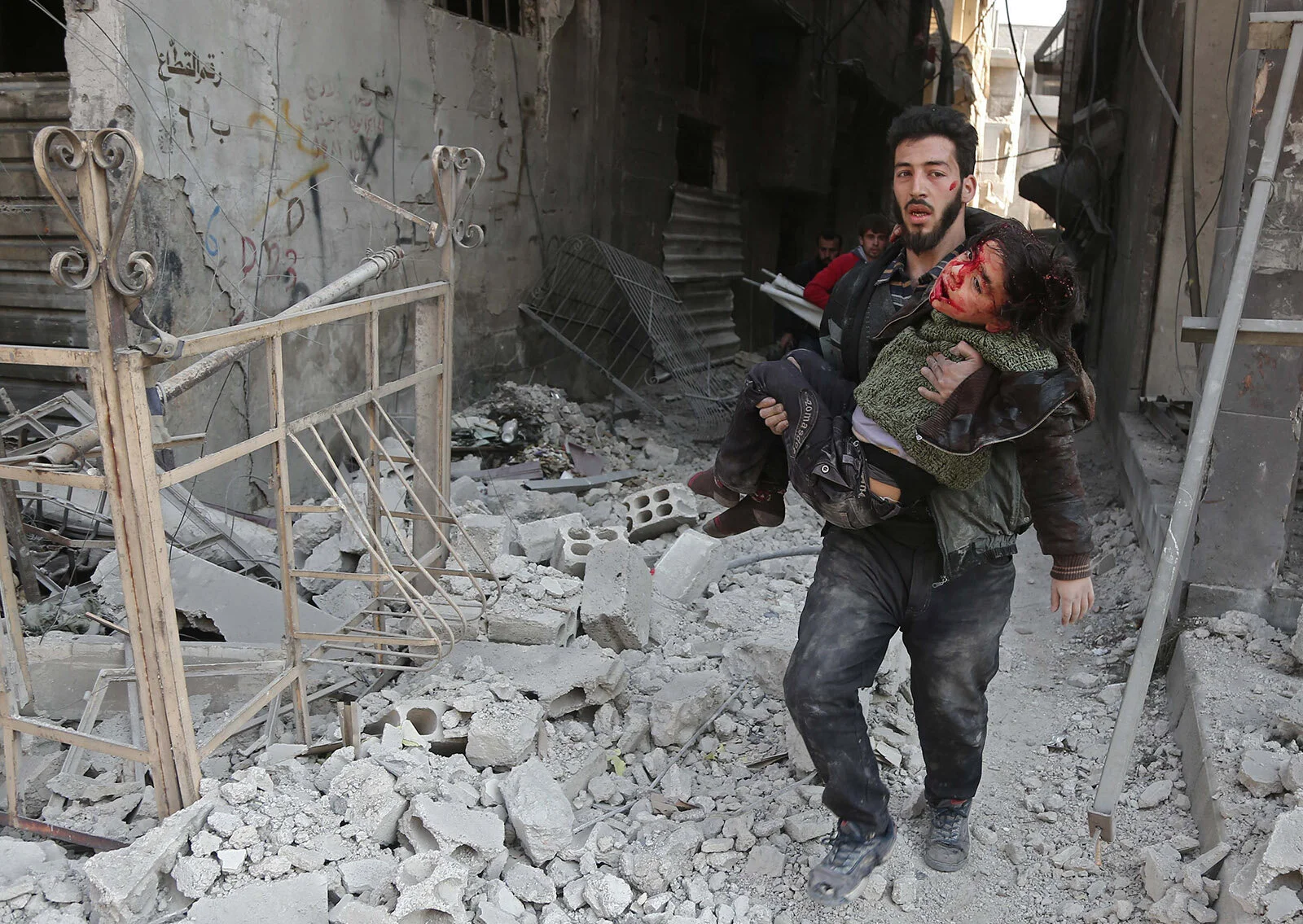 A Syrian man rescuing a child after an air strike on eastern Ghouta, near Damascus, on February 21.