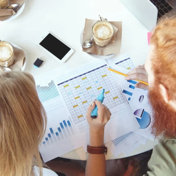 Un homme et une femme collaborent sur un projet concernant le rôle de la structure financière dans la collecte de fonds.