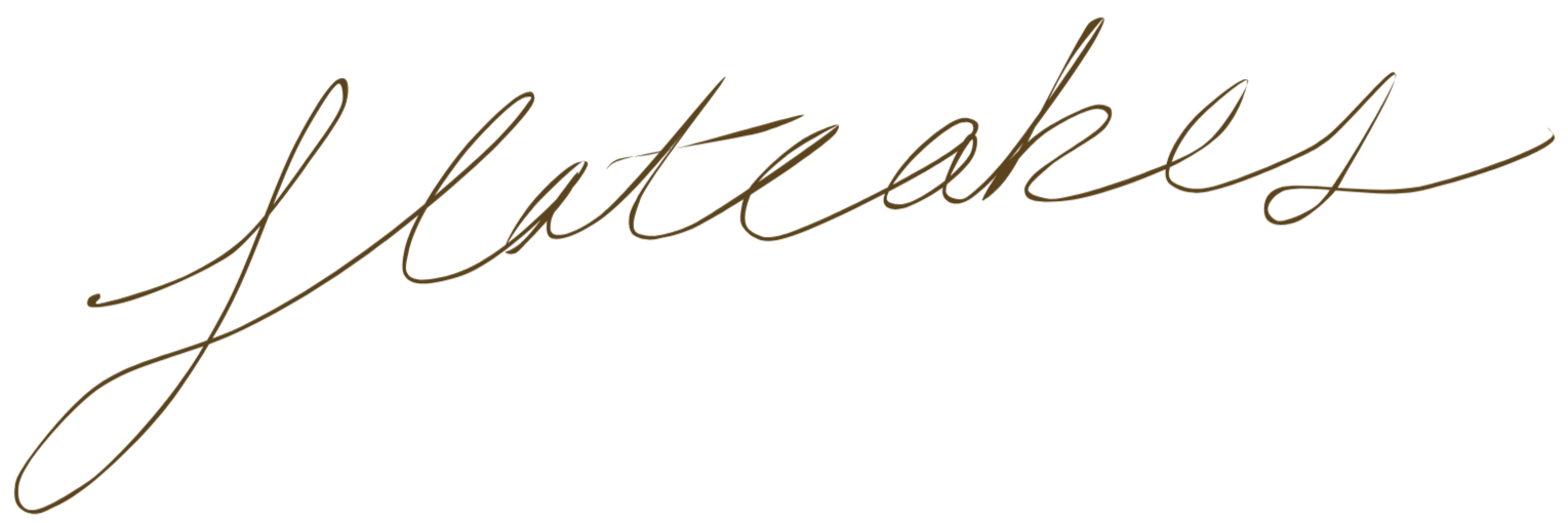 A logo with cursive stylized gold script that says "flatcakes".