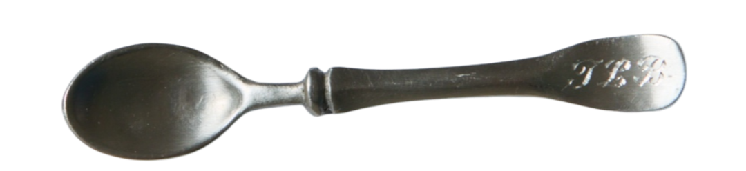 Silver spoon with engraved initials 'T. B.' on the handle.