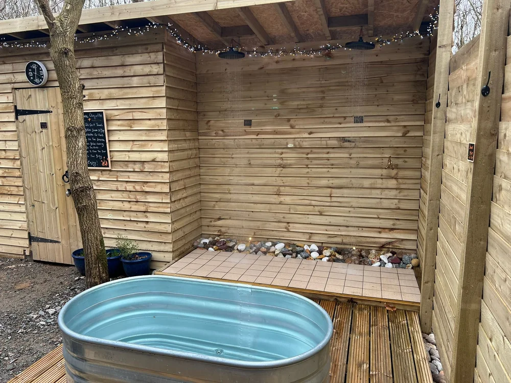 Outdoor showers beside the woodland sauna