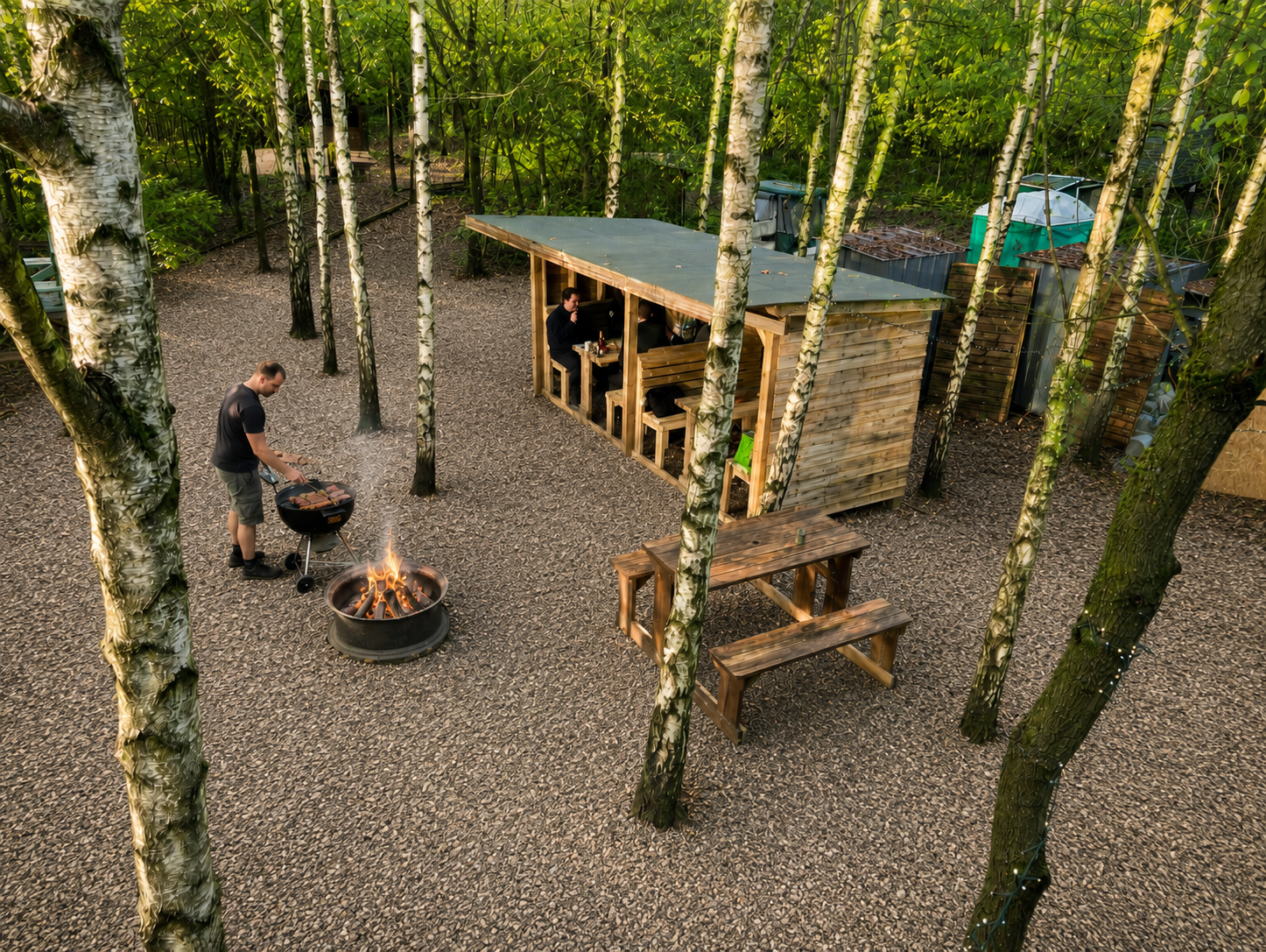 Communal BBQ and fire area behind reception at Fire & Stars Woodland Camping.