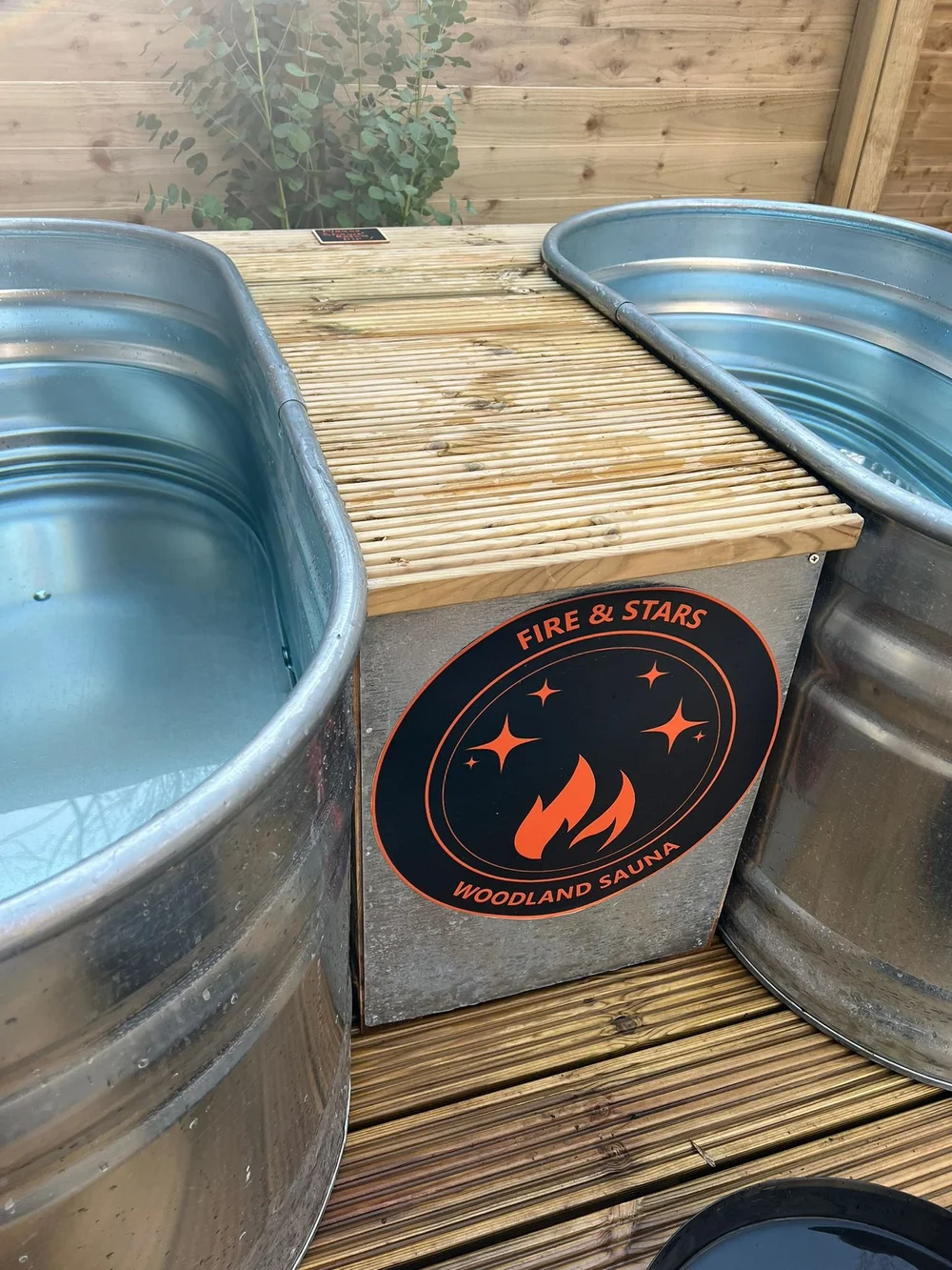 Two cold plunge tubs beside the woodland sauna