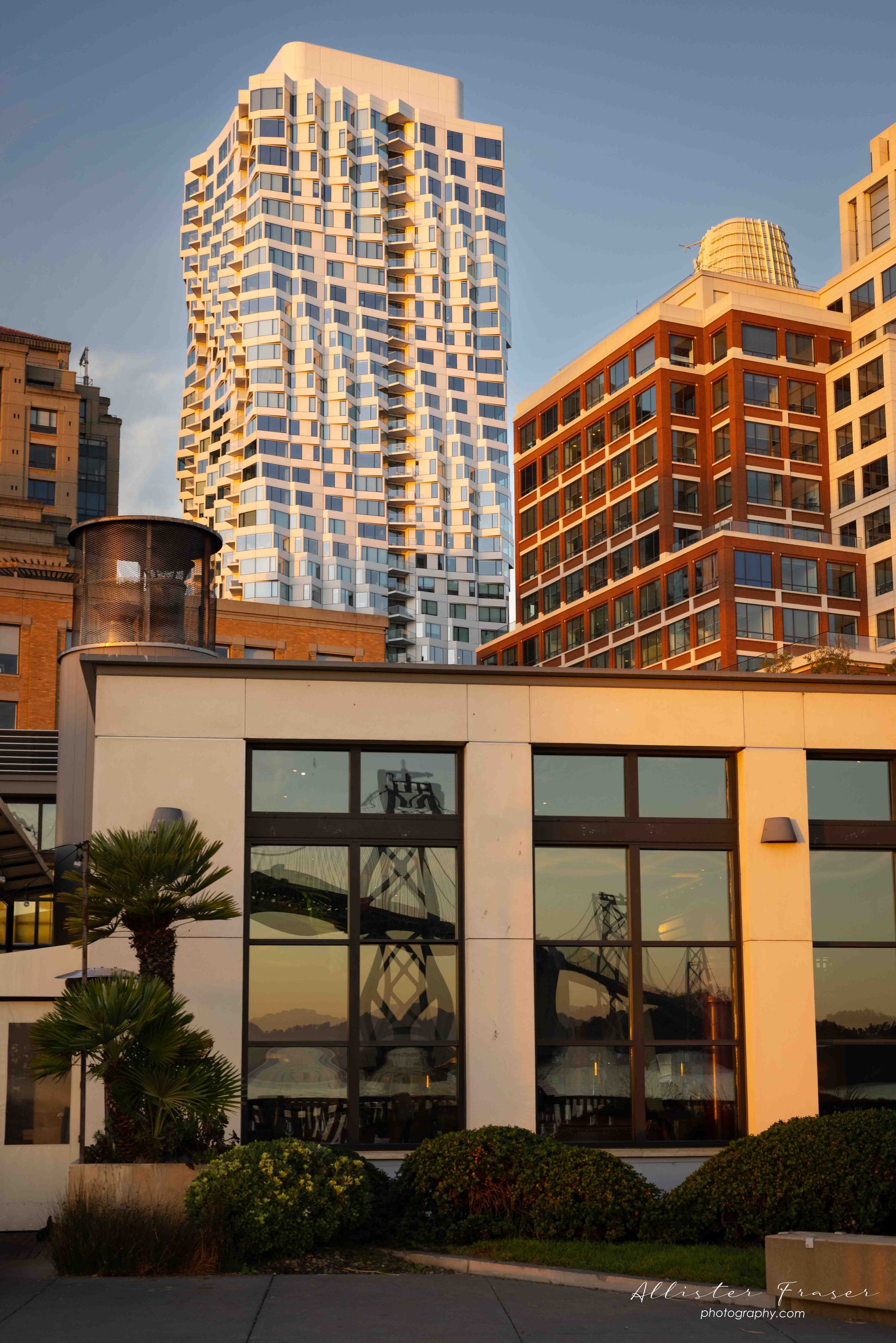 the twisting mira tower with bay-bridge reflections in the warm morning sunrise