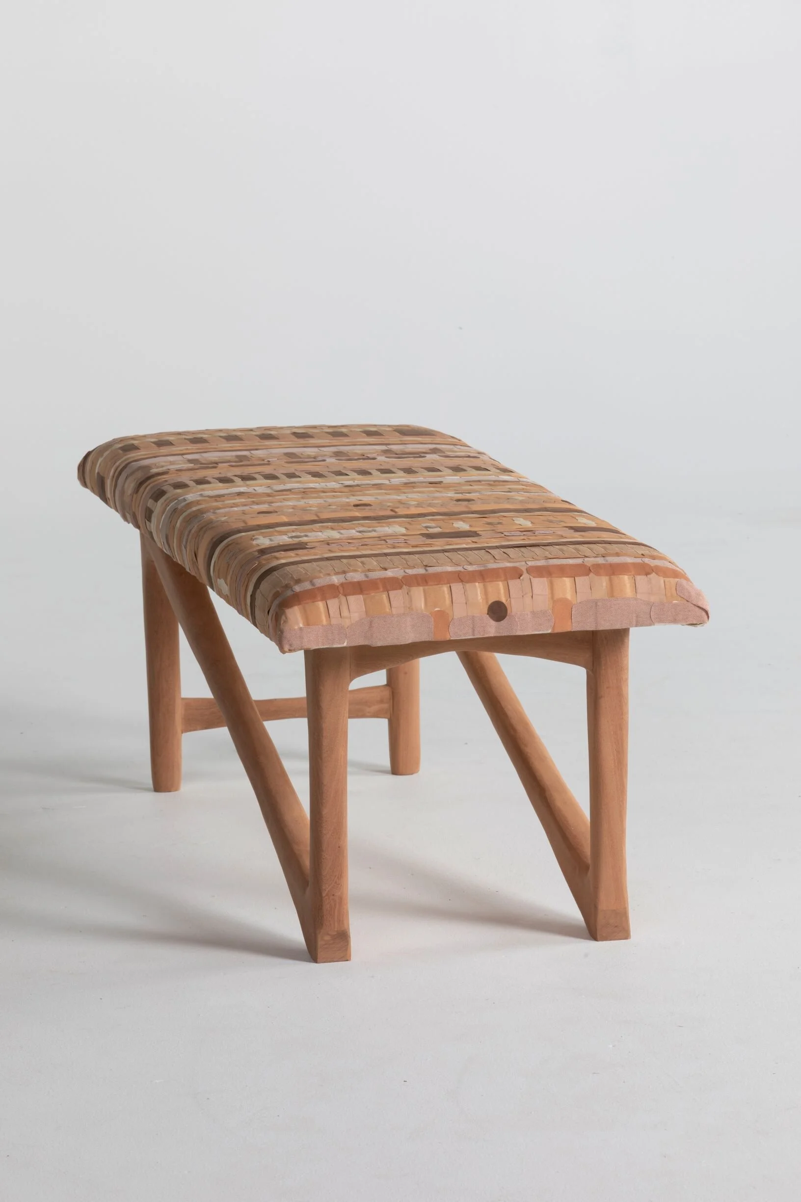 Small wooden stool with a woven rattan seat on a white background.