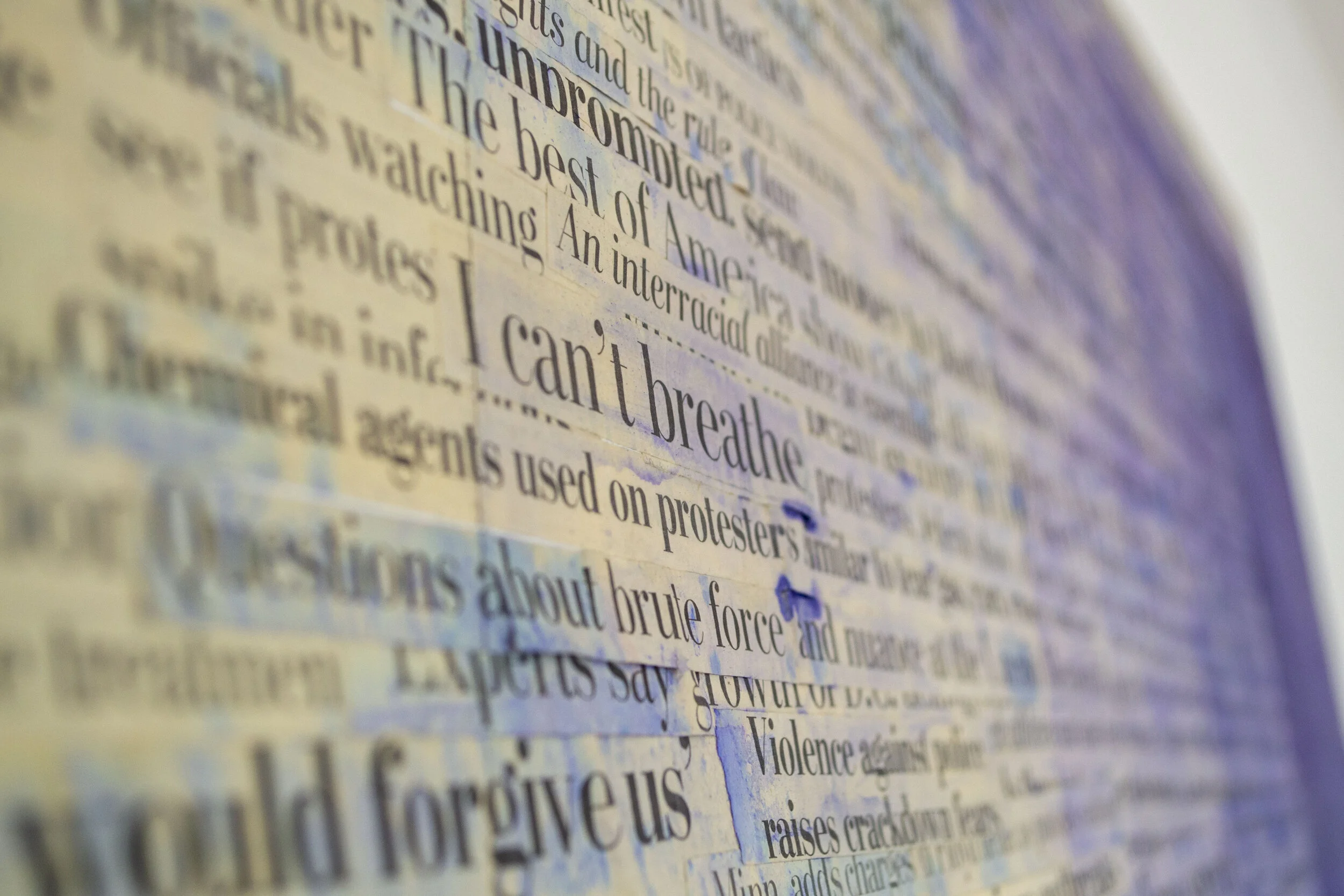 Close-up of a collage of printed newspaper text with prominent words 'I can't breathe' and blue watercolor stain.
