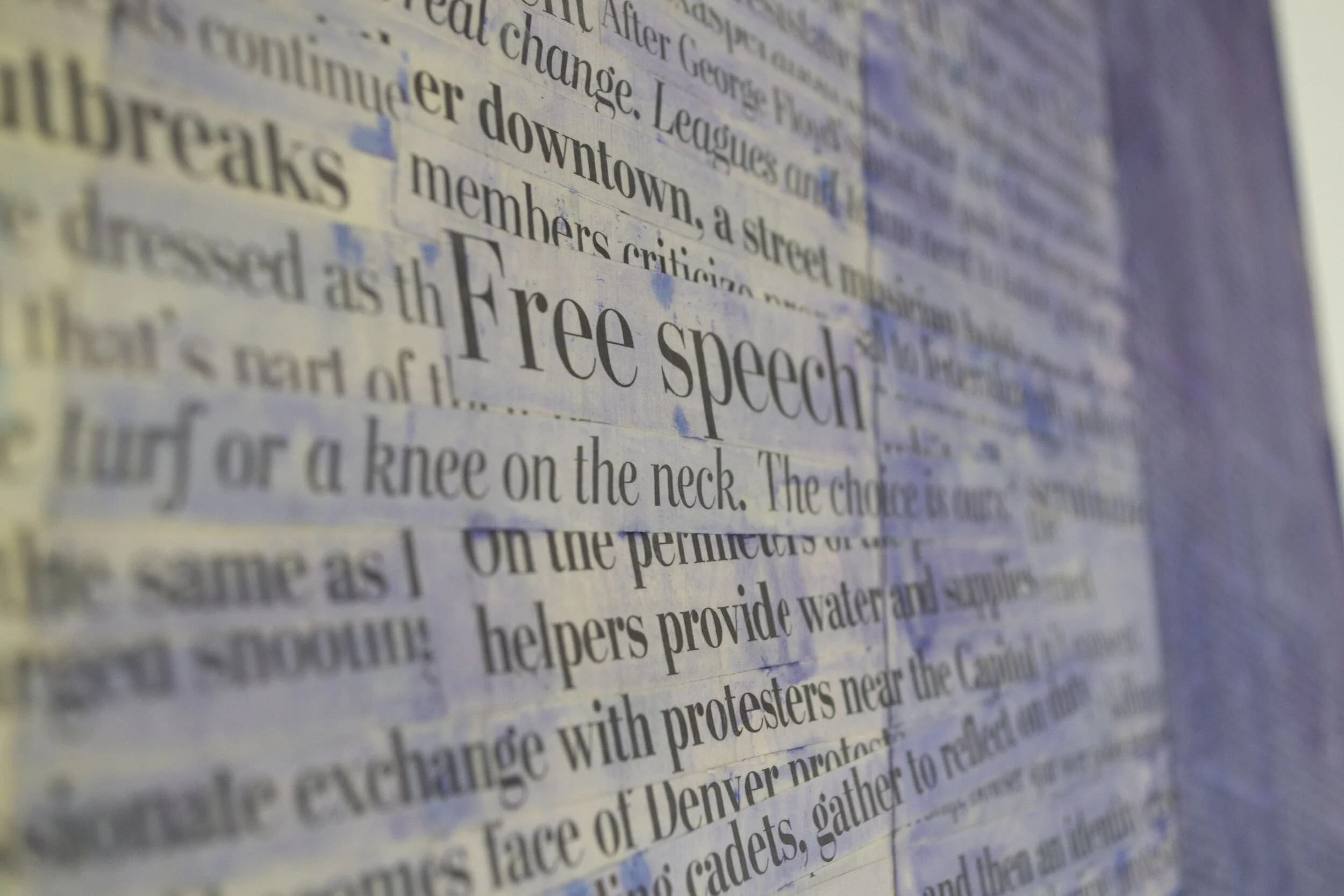 Close-up photo of newspaper articles with the prominent headline reading 'Free speech'.