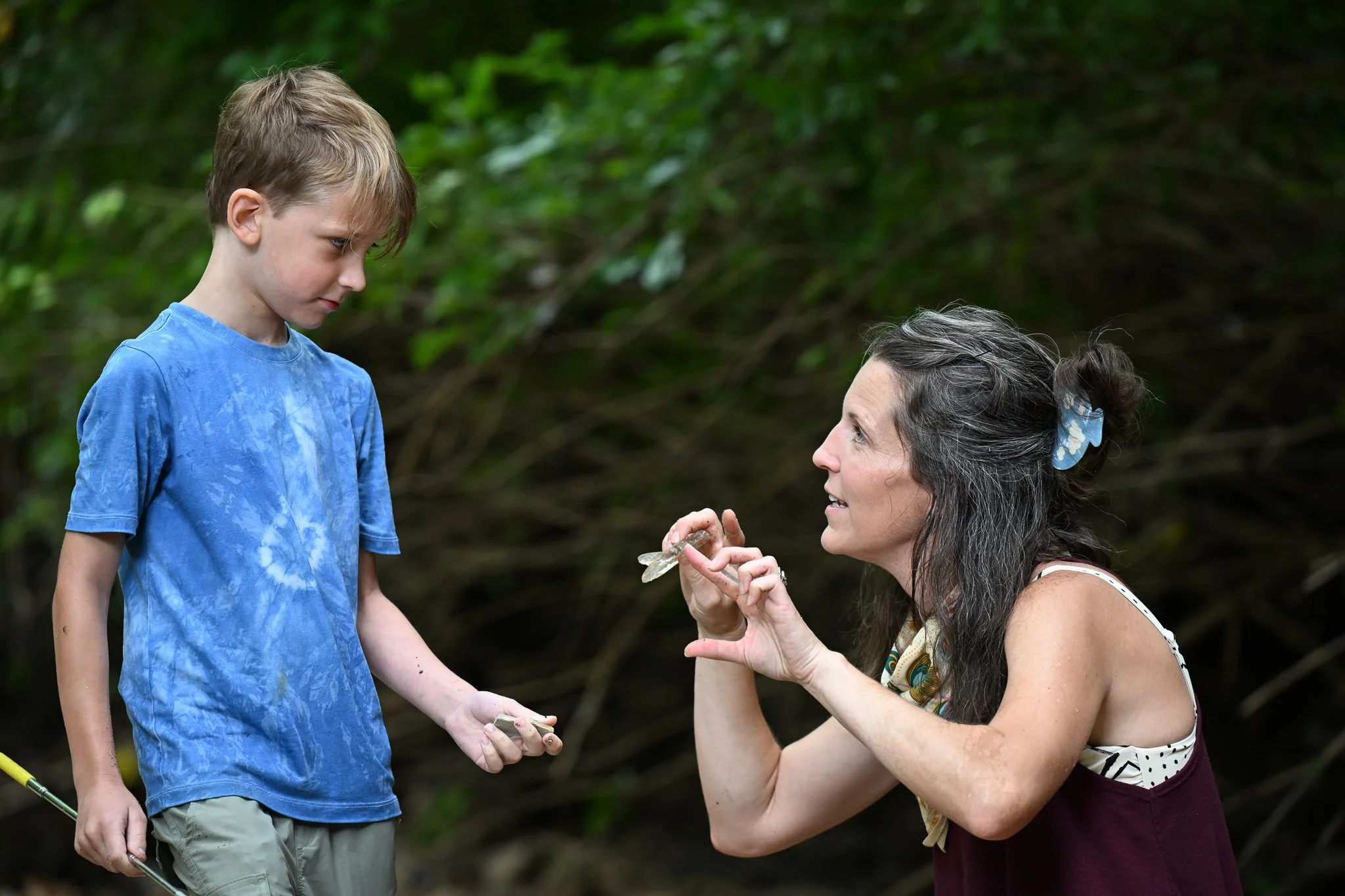 Ali Freeman discusses with her son Lochlan, 8, about a piece of glass that they found at Flat Branch Creek on Wednesday, June 24, 2026, in Columbia. Lochlan said he  enjoys going out with his mother on her treasure hunts.