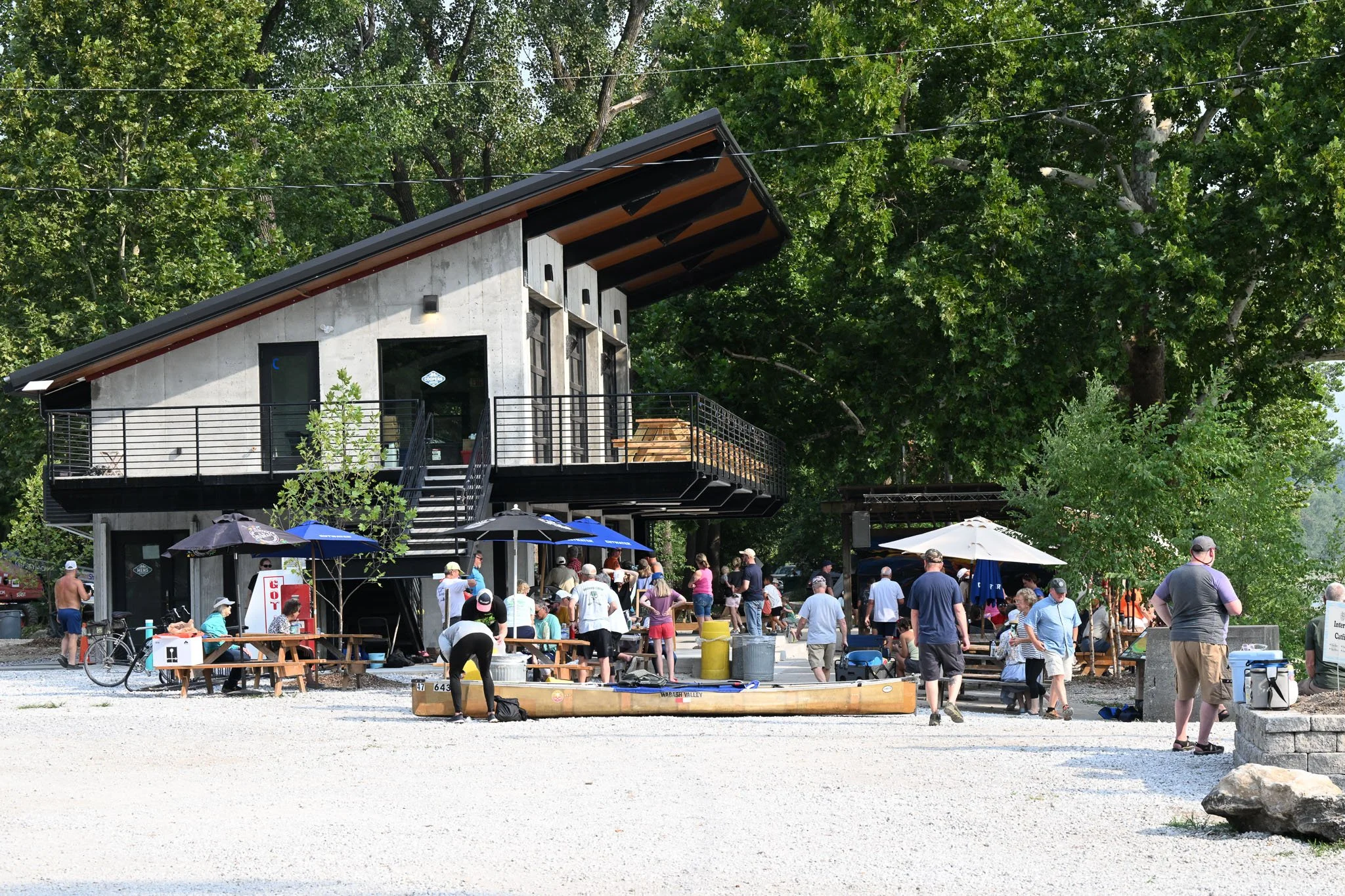 Spectators mingle around the Cooper’s Landing general store during the MR340 race on Wednesday, July 29, 2026, in Columbia. “Ground Crews” of family or friends follow along the river to support and resupply racers when they stop at boat ramps to rest