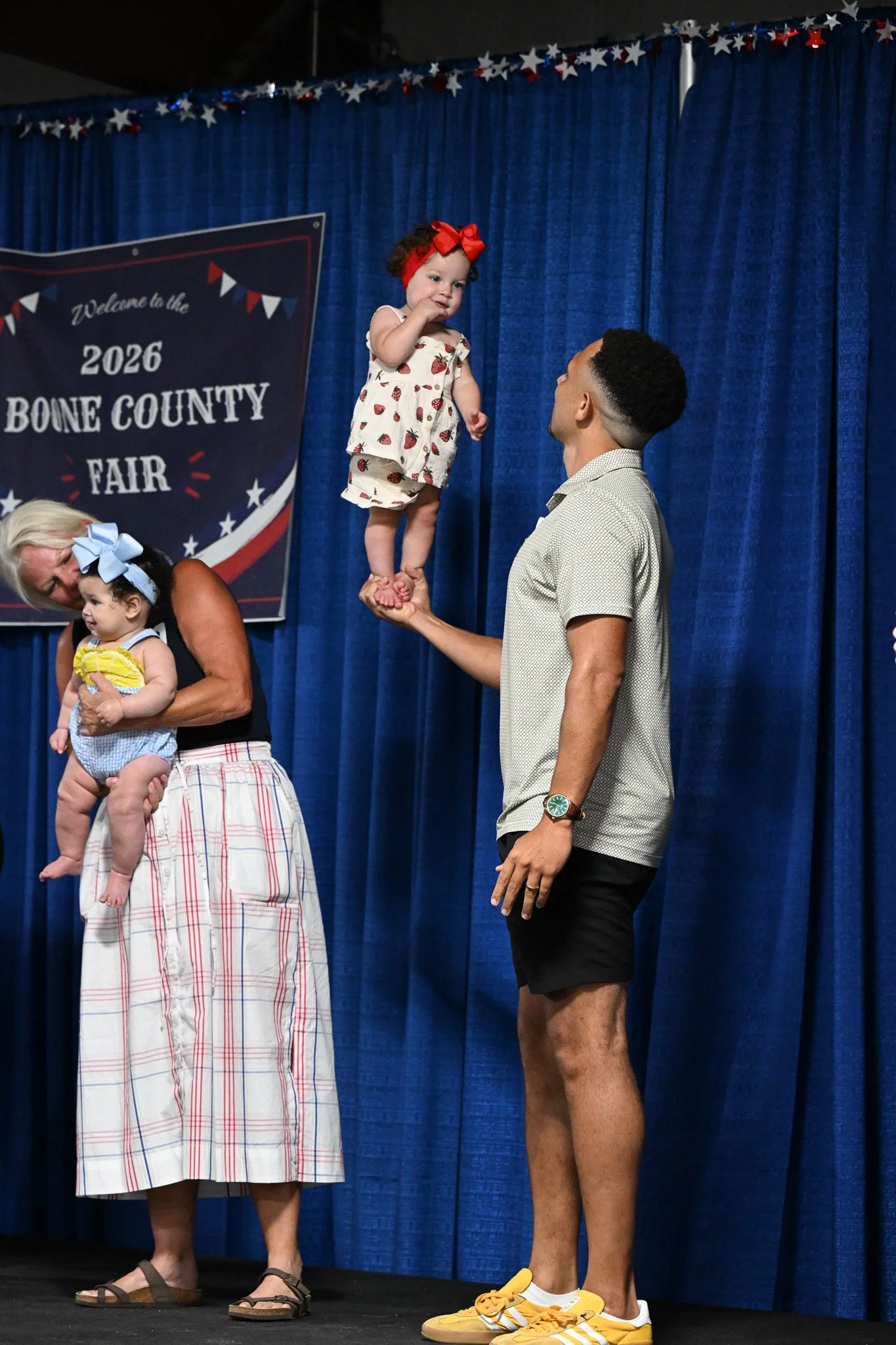 Miquel Hudson balances his daughter, 11-month-old Pippy Hudson, on stage during the baby contest at the Boone County Fair on Tuesday July 21, 2026, Northeast Regional Park in Columbia. “(We) came out to enjoy the fair this evening, came for a corndog