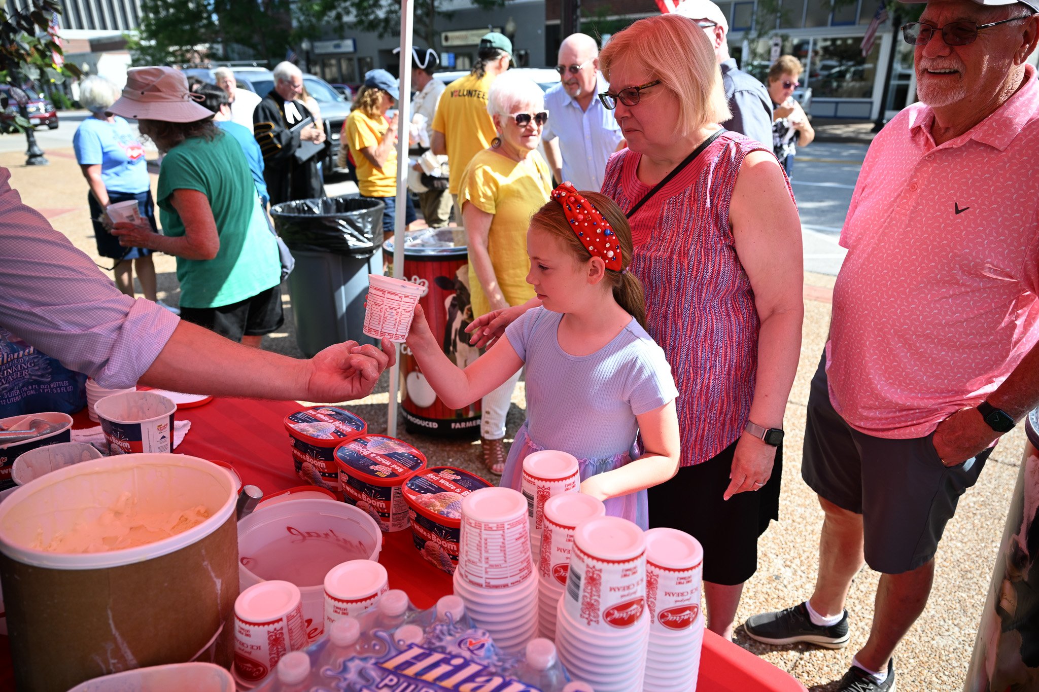 Sophia Adams, 8, of Russellville, Missouri, gets ice cream with her grandparents, Cindy Lambert, center, and Steve Lambert, right, before the reading of the Declaration of Independence on Monday, July 8, 2026, at Cole County Courthouse in Jefferson C