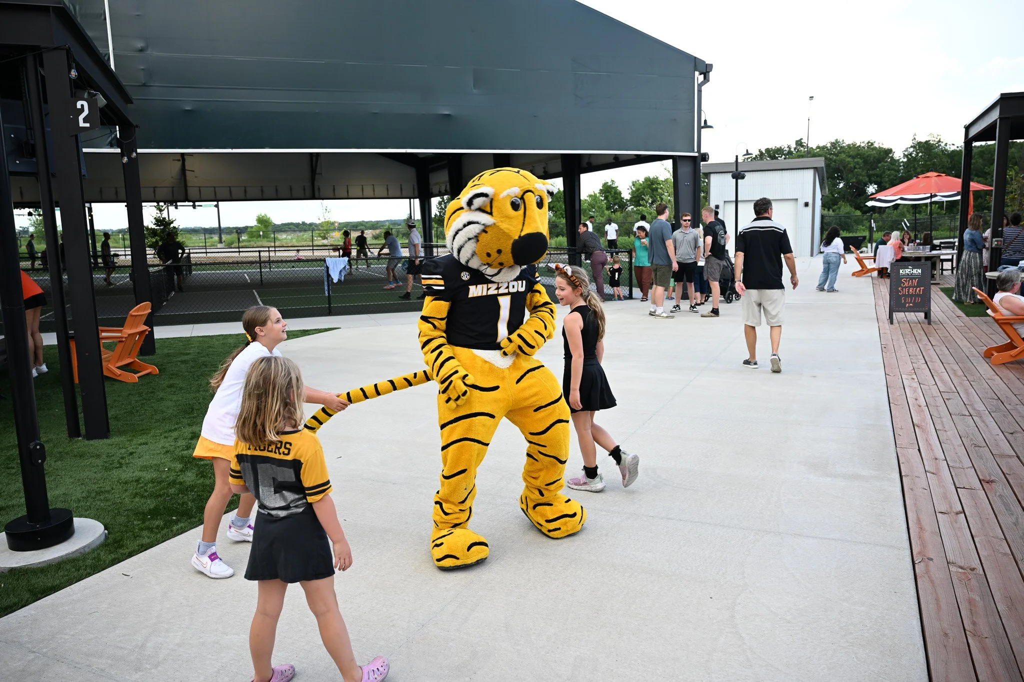 From left Anna Grant, 6, Kiley Harper, 8, and Kade Grant, 8,  harass and pull the tail of Truman the Tiger at the Zou to You event on Wednesday, June 24, 2026, at the Kitchen Bar and Grill in Columbia. This was the final stop for the Zou to You tour 