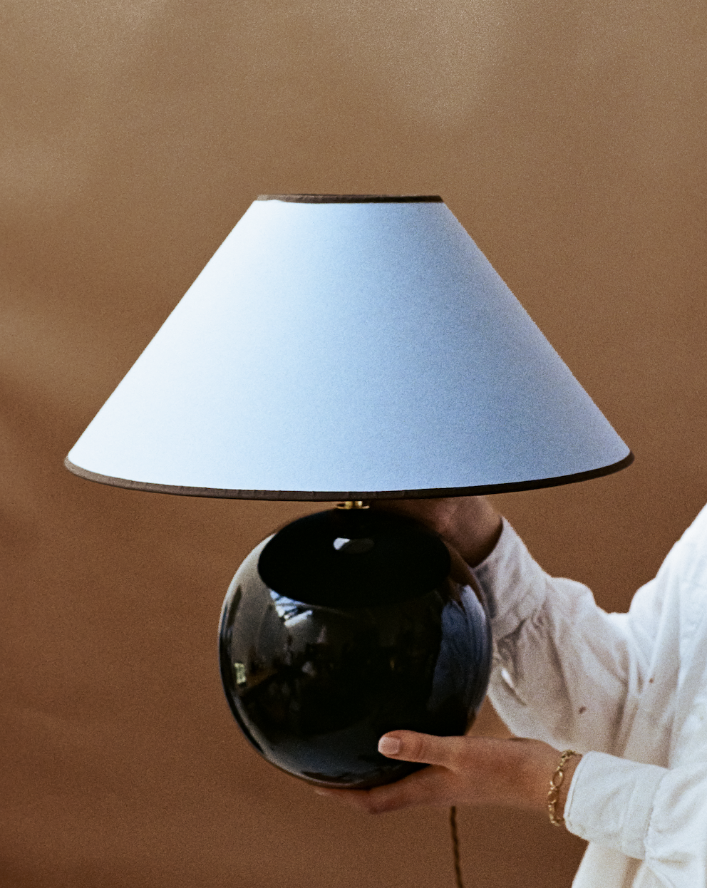 A spherical black wooden lamp with blue lampshade by Hum London