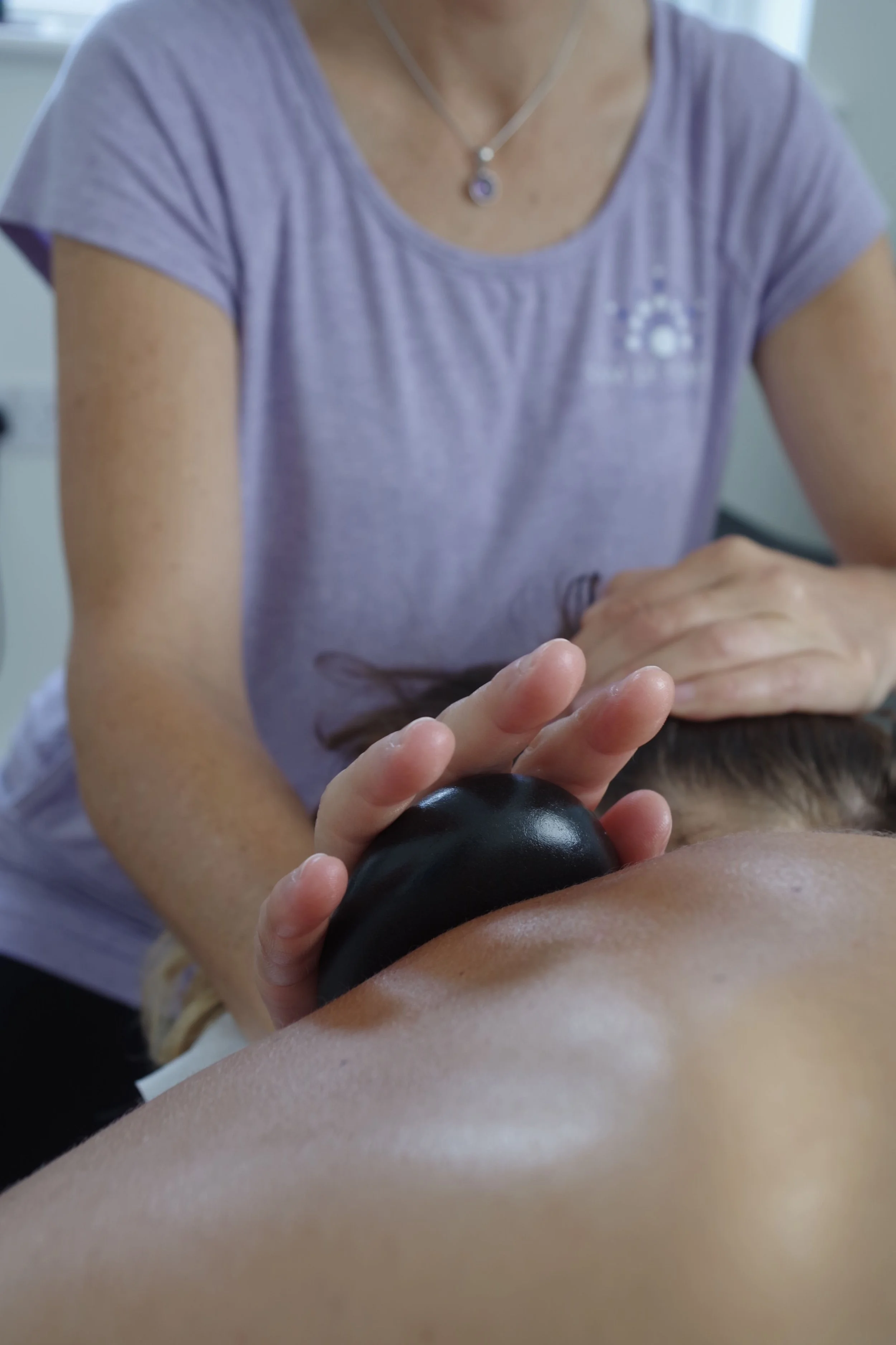 Client Receiving Therapeutic Hot Stone Massage from Sam Le Compte