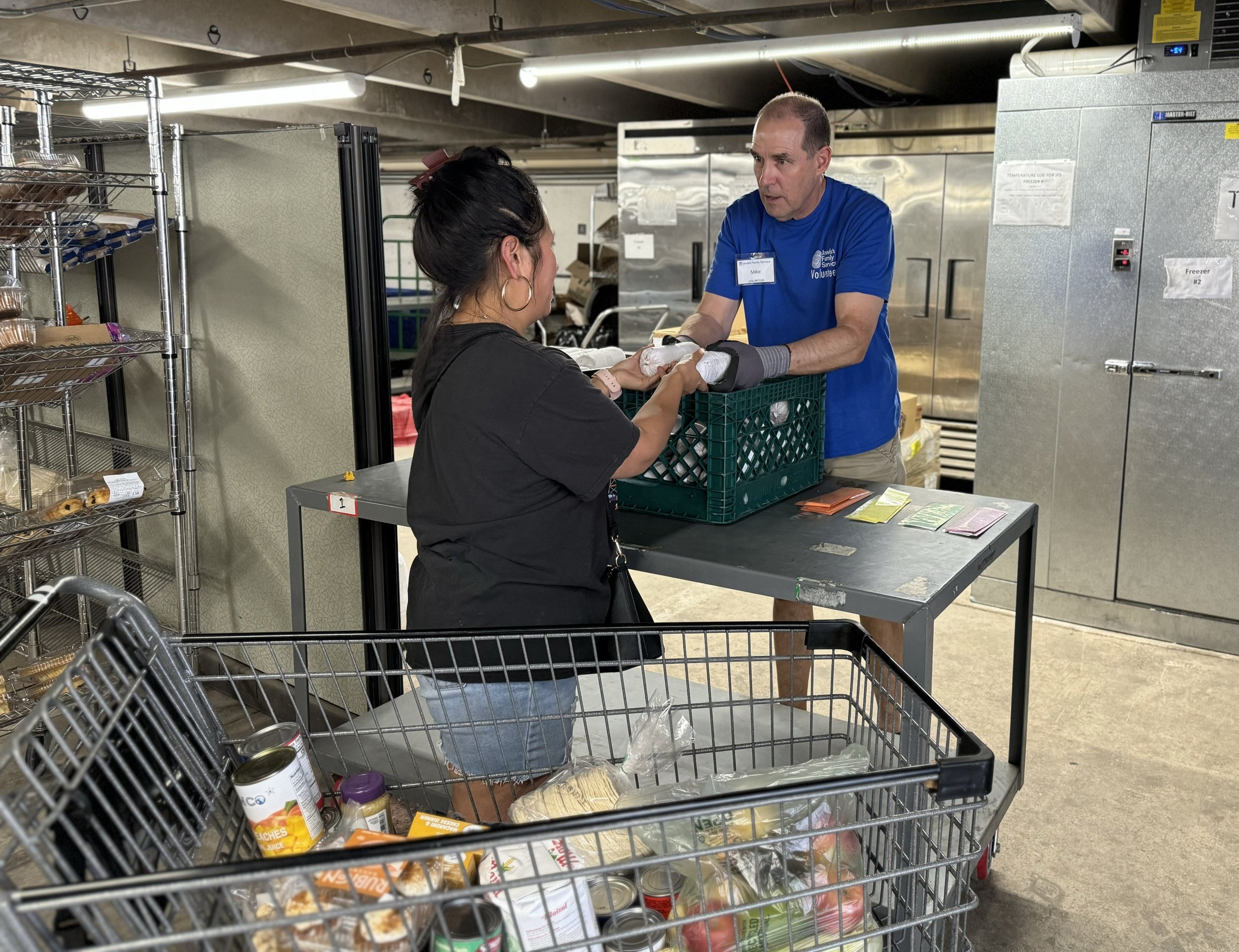 Volunteer handing out food at a pantry.