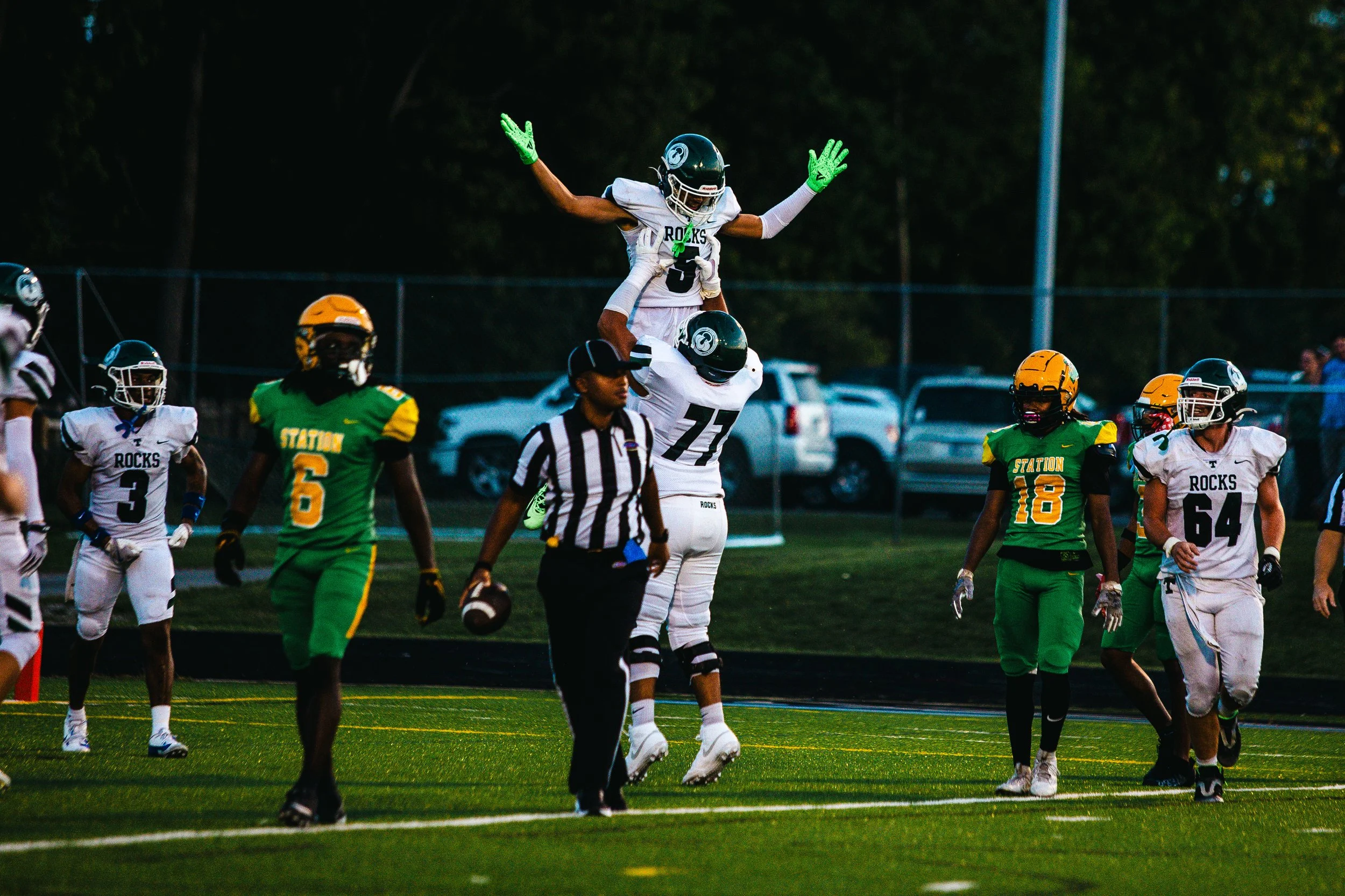 Football players in Green and White jerseys celebrating during a game