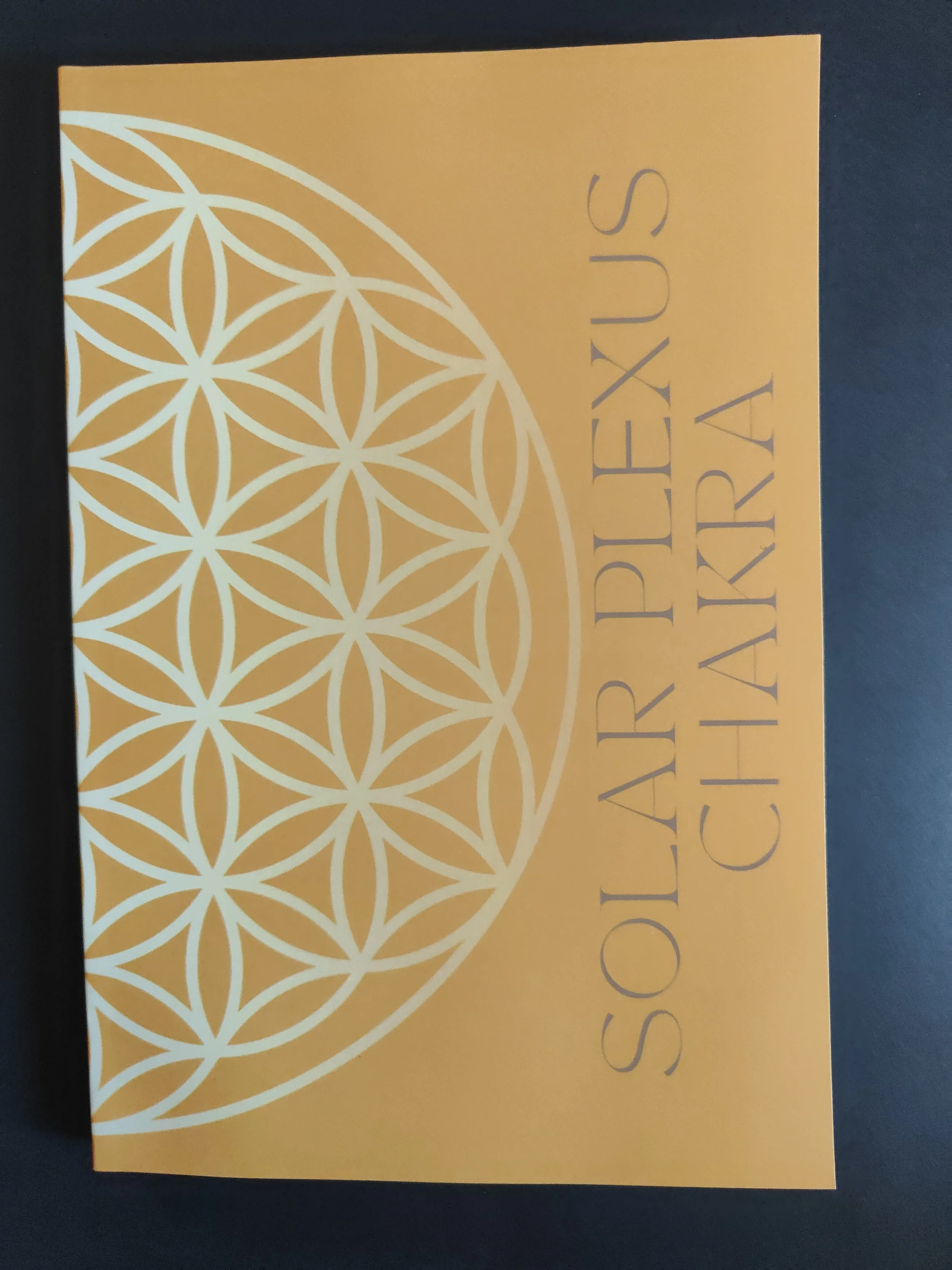 Orange card with white geometric pattern and the words 'Solarlie Plexus Chakra' written vertically.