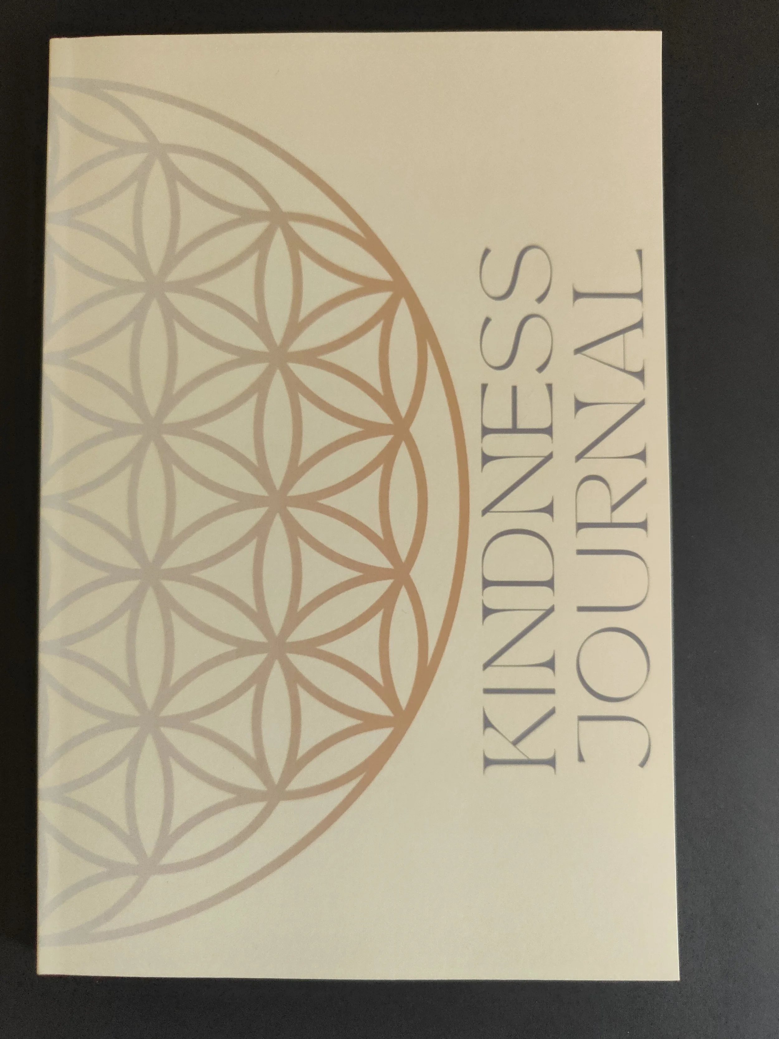 Box with the words "Kindness is contagious" and a geometric circular pattern design on a light yellow background.