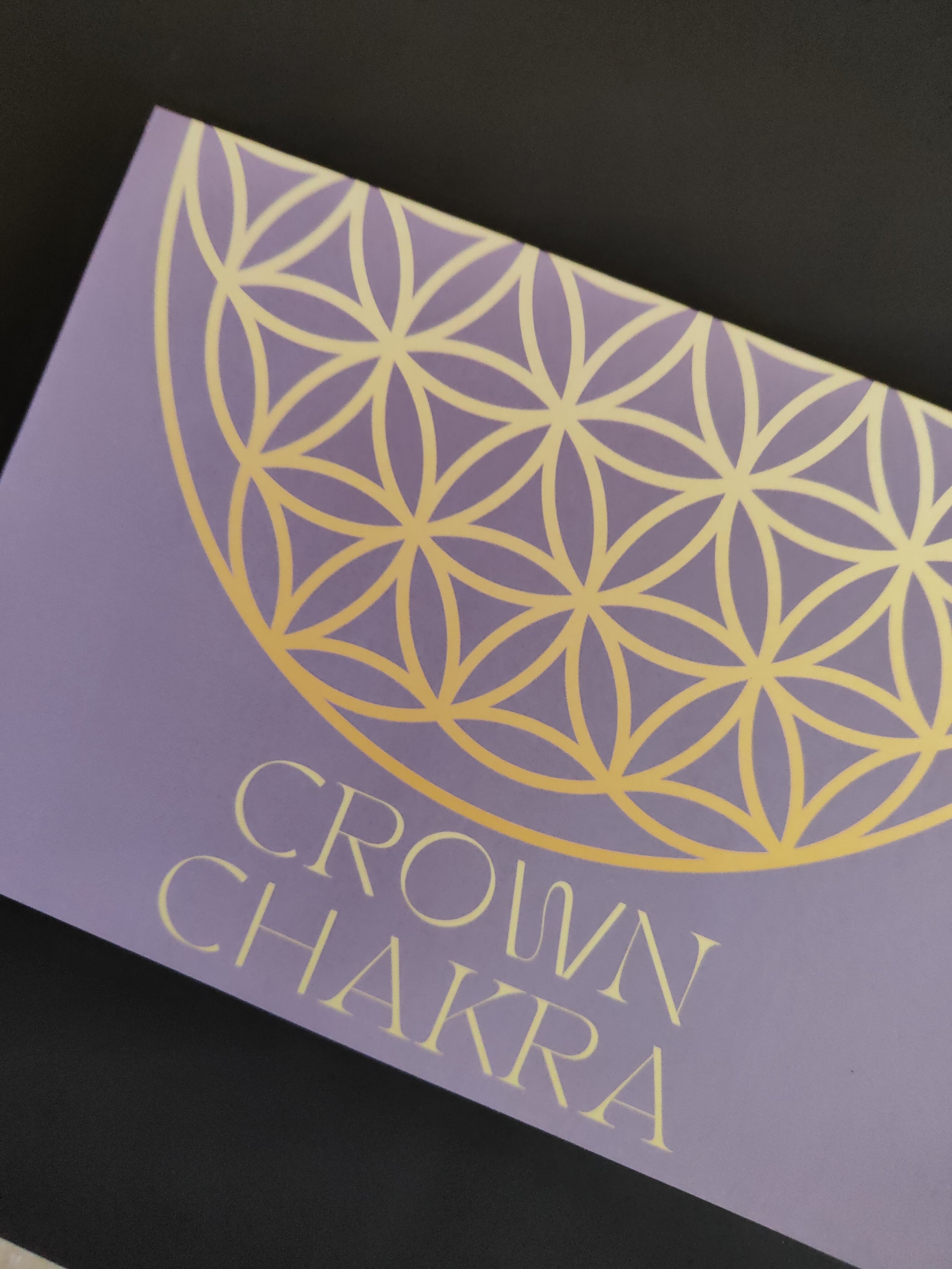 Purple packaging for Crown Chakra candles featuring a gold geometric flower of life pattern and text that reads "Crown Chakra."