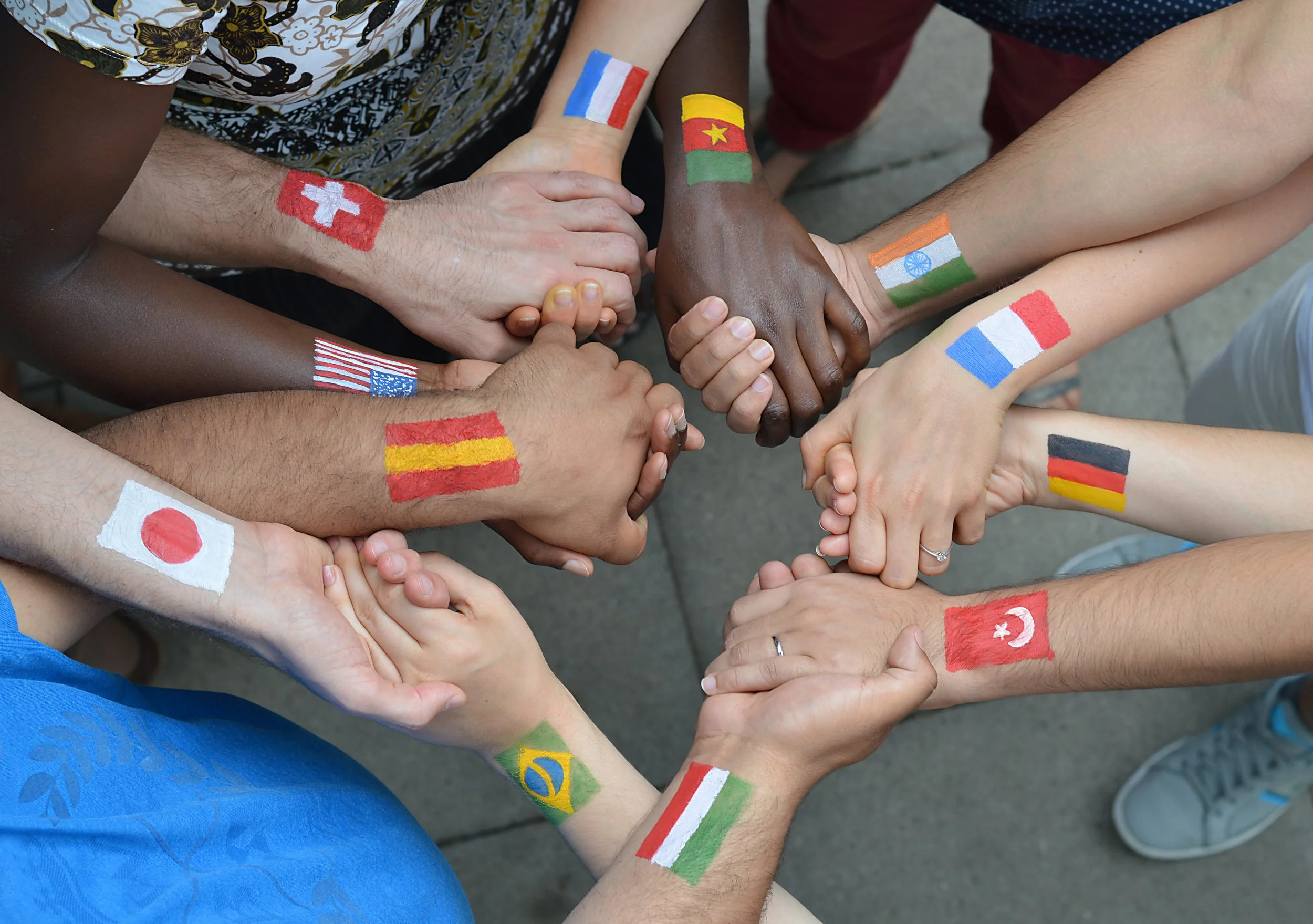 a circle of joined hands painted with international flags yoga for trauma bessel van der kolk ptsd how to heal trauma trauma informed yoga  the body keeps the score