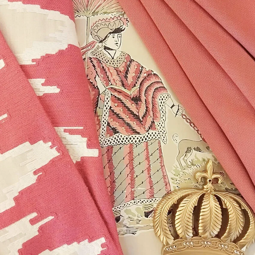 Close-up of pink and white patterned fabric, partly covering a vintage-style illustration of a woman dressed in historical clothing, with a gold decorative crown in the foreground.