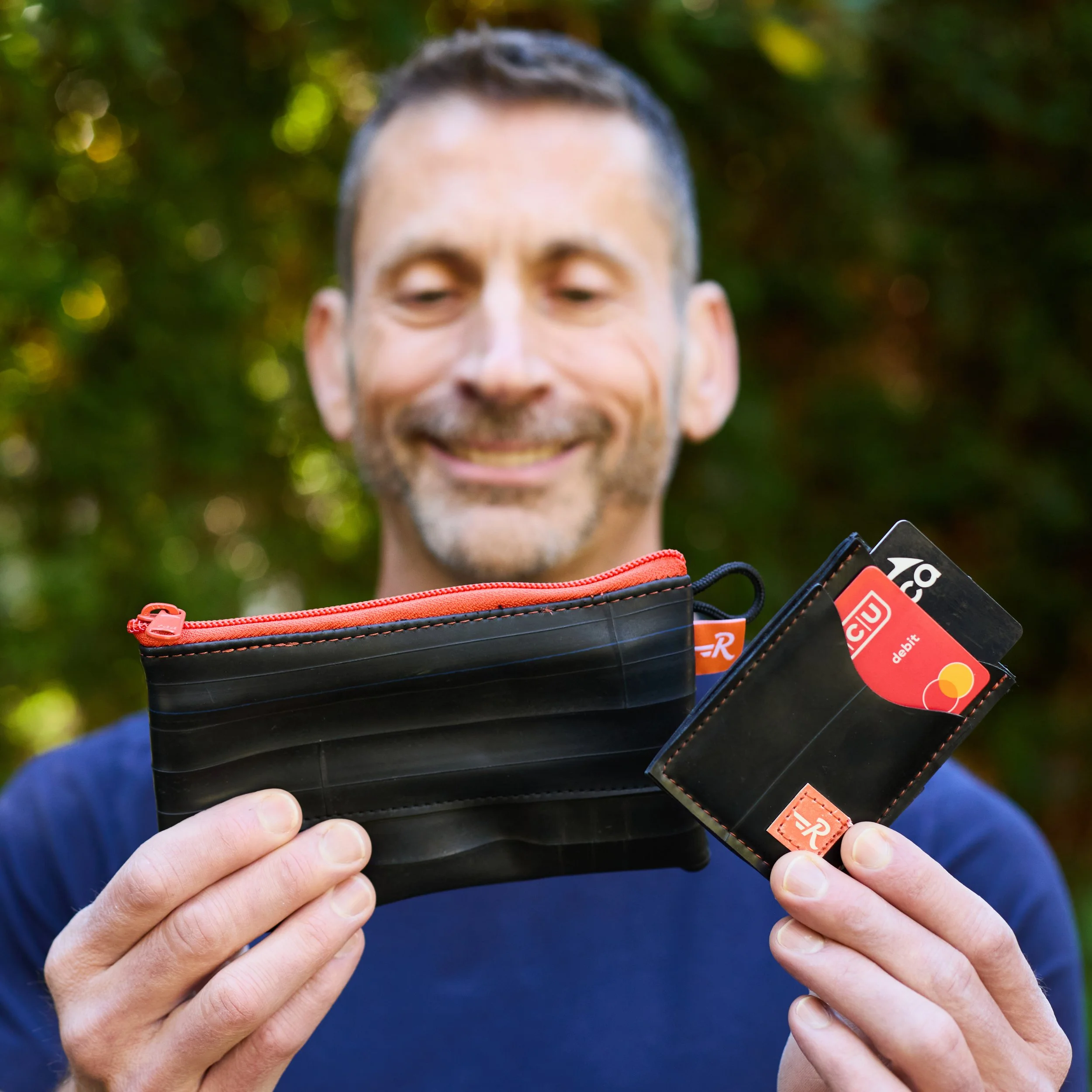 Man holding tire tube pouch and wallet