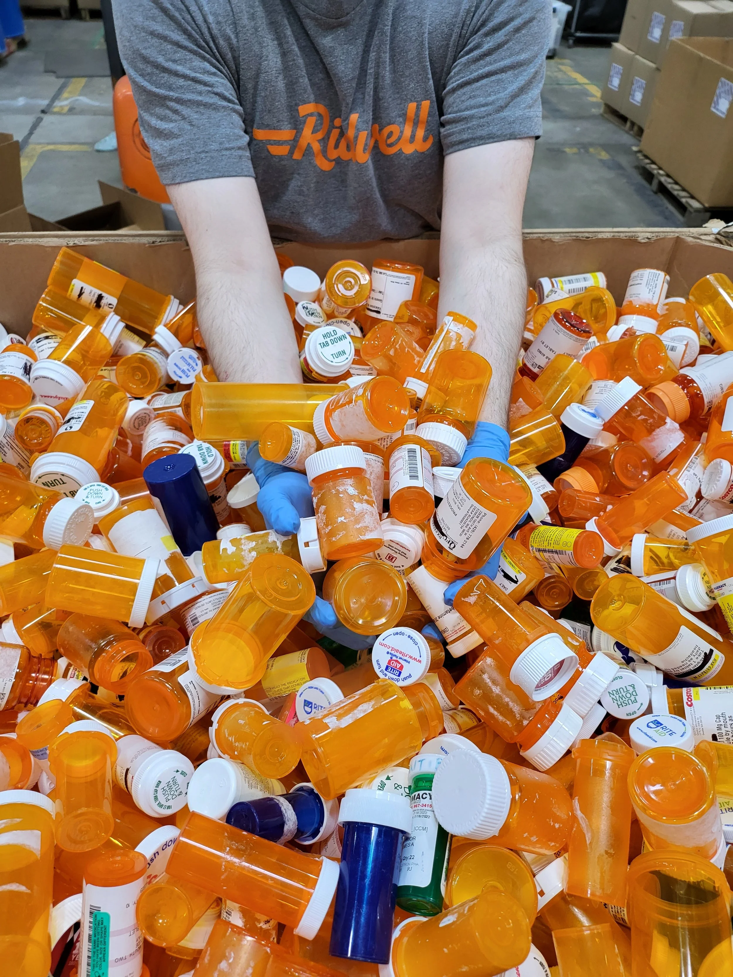 Ridwell employee with box full of pill bottles