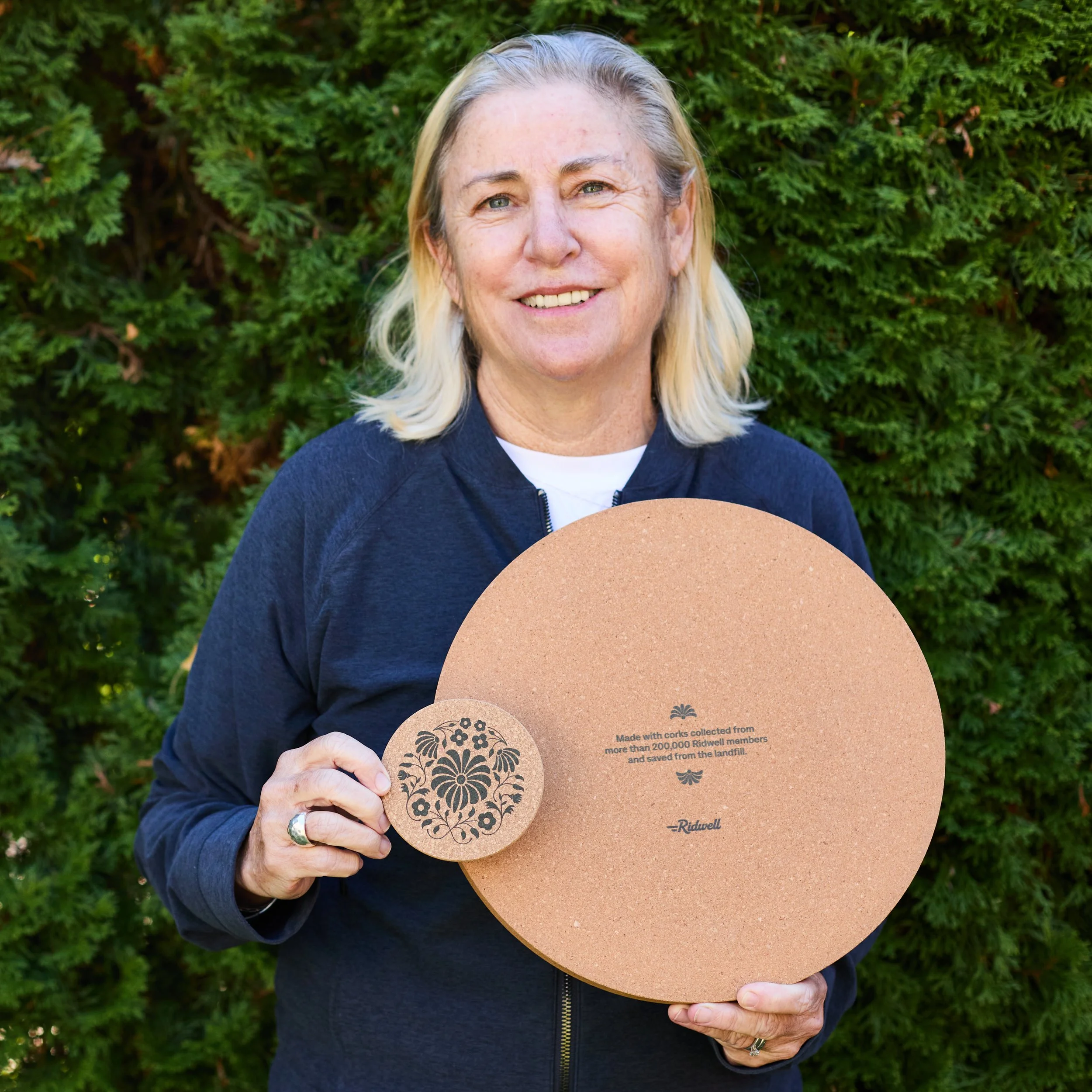 Smiling woman holding cork tray and coasters