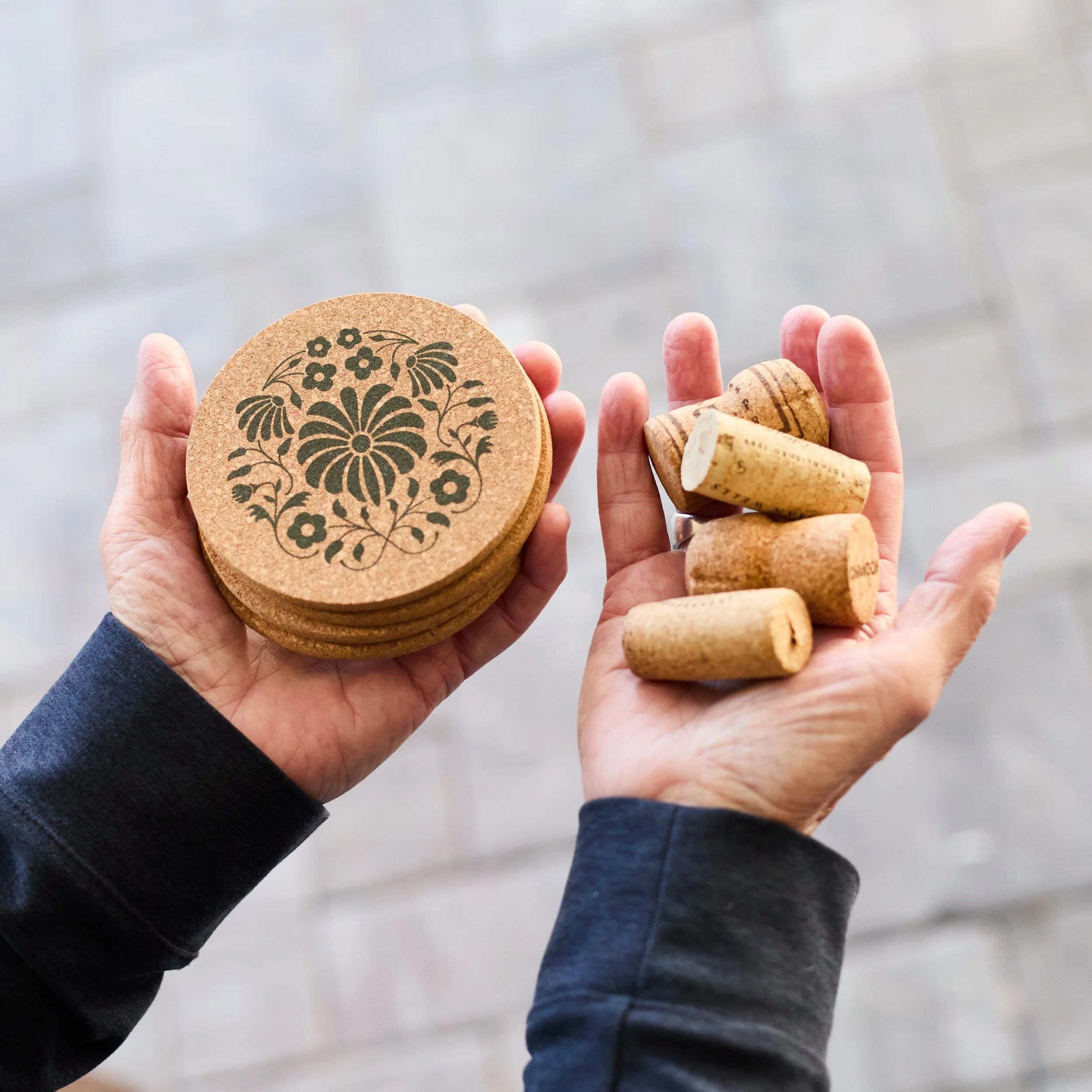 Woman holding corks in one hand, coasters in the other