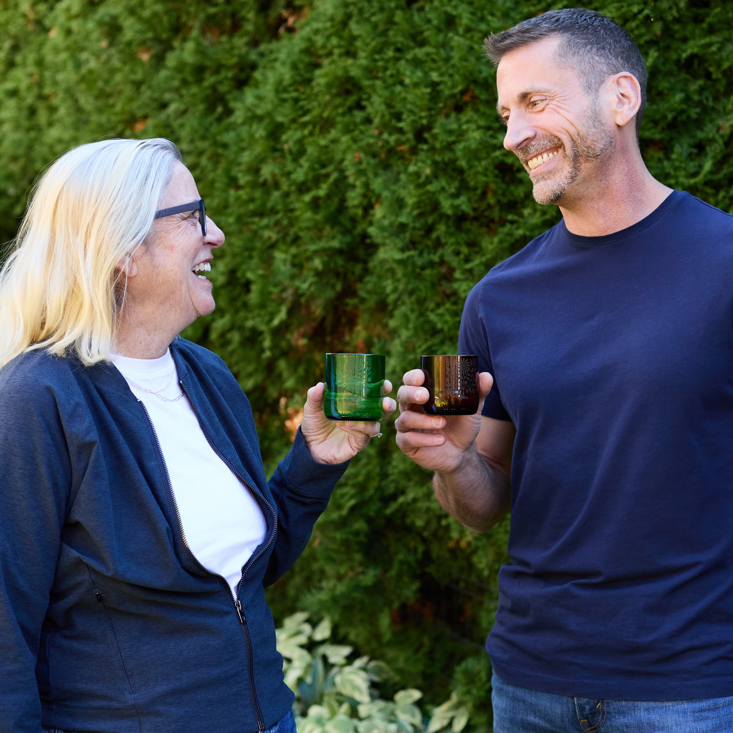 Woman and man toasting with upcycled glass drinkware